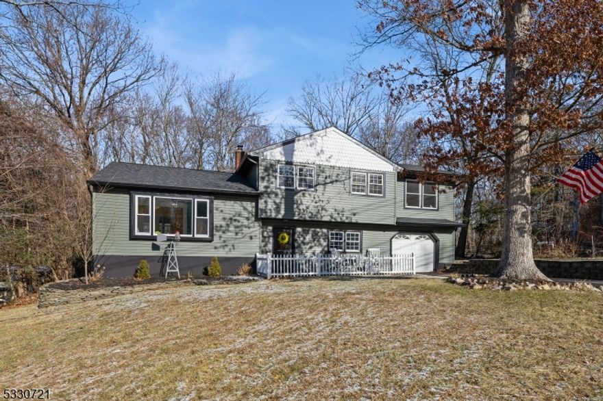 Move right into this stunning 4-BR, 2-BA split-level home with a 1-car garage, set on a private lot less than 5 miles from Greenwood Lake. Extensively renovated from 2020-2024, this home blends modern upgrades with timeless charm and a functional layout. The lower level welcomes you with a foyer, coat closet, pantry, and a family room featuring a spacious bar area, cozy wood-burning stove,a updated full bath, brand-new sliders to the patio, and direct access to the garage.  The main level boasts a bright LR, DR, and remodeled kitchen with wood-look tile floors, SS appliances, cathedral ceiling, skylight, and sliders to a 21' x 11' screened-in deck (2024) overlooking the private backyard ? perfect for bug-free outdoor living.  The 2nd floor includes all 4 BRs with updated lighting, new hardwood floors, and an updated main bath featuring vaulted ceilings, skylight, and double sinks. The large primary BR stands out with floor-to-ceiling hardwood floors and an electric fireplace for a cozy feel.  The finished basement offers a versatile rec room with recessed lighting, currently used as an office, next to the laundry/utility room. Key updates: new roof (2020), septic for 3 BR (2020), paved driveway (2023), front door (2024), gutters (2024), front siding (2024), and updated baths (2024). Conveniently located .2 miles away from Elementary school, 1 mile from ShopRite and near NYC transportation, this home offers both privacy and convenience. Schedule your showing today!