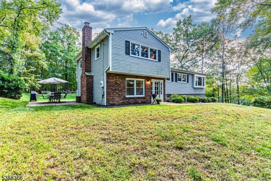 Welcome to 9 Whitman Drive, a beautifully updated split-level home nestled on over 1 acre in the desirable Denville. This sophisticated residence seamlessly blends classic charm with modern comfort, offering 3 spacious bedrooms, 1 full bath & 1 half bath, and approximately 1,888 sq ft of living space. As you step inside, you'll be greeted by a bright, inviting living room featuring hardwood flooring & large windows that fill the space with natural light. A formal dining room transitions easily into a well-appointed galley kitchen, complete with updated appliances & efficient layout. The home's split-level design offers versatile living areas, including a generous family room on the lower level-ideal for movie nights, a play area, or cozy gatherings around the wood-burning fireplace. Three comfortable bedrooms await, each offering ample closet space & serene views of the mature, wooded yard. The full bathroom includes classic touches, while a conveniently located powder room serves guests. Outside, the property impresses with its generous 1.08-acre lot-rare in this market.  The yard is part woodland, part open perfect for gardening, outdoor entertaining, or future expansions. You'll also find a patio area & a 2-car attached garage with driveway access. Enjoy proximity to top-rated public & private schools, commuter access (NJ Transit station & bus stops nearby), & charming local shops, parks, & dining in downtown Denville. Don't miss your chance to own this unique property.