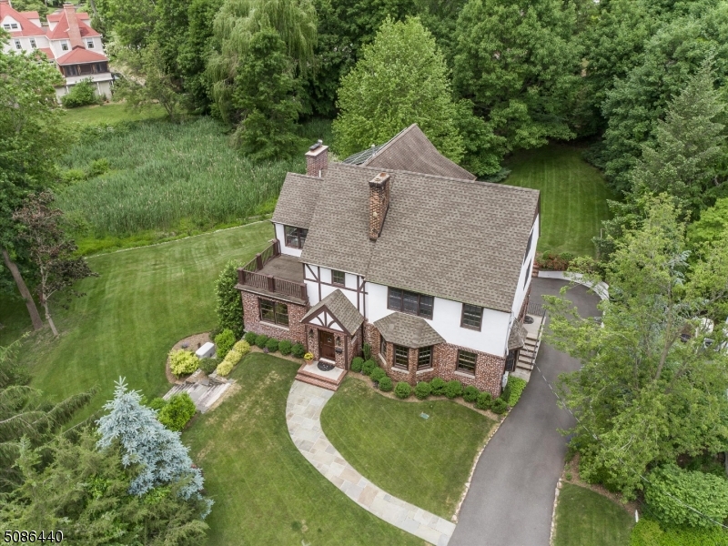 Located in the highly sought after Old Short Hills neighborhood, this exquisite updated Tudor home, features 5 bed/4.2bath, nestled on 1.27 acres of sprawling, private property, 3 car garage. Gleaming wood floors lead from formal dining room to oversized living room.White kitchen w/stainless steel appliances, center island, granite countertops, open to breakfast area w/sliders to the deck, adjacent to family room w/ built-ins.Convenient home office & 1st floor laundry room.Master suite w/his & her WICs & 1 of 4 fireplaces.Master bath includes dual sinks, glass enclosed shower & soaking tub. Private 5th bedroom on 3rd floor w/cedar closet & addl finishable attic space. Walk-out basement w/art room & rec room. Generator, new roof, solar panels. Low taxes! Super close to SH train & SH Racquet club pool!
