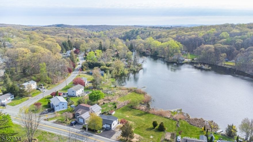 Welcome to this fully renovated lakefront gem in the desirable Mount Glen Lakes section of West Milford. Set on an oversized, level 0.40-acre lot with direct lake frontage and year-round water views, this 3-bedroom, 2-bath ranch offers the perfect blend of modern design and effortless one-level living. Completely redesigned in 2025, every detail has been thoughtfully updated for today's lifestyle. Step inside to a bright, open living/dining area with beautiful wood floors and abundant natural light. Sliders off the living room lead to a deck overlooking the lake   the perfect place to relax or entertain while enjoying peaceful waterfront scenery in every season. The stunning new kitchen features sleek cabinetry, stylish countertops, and stainless steel appliances, including a gas range.  One bedroom features its own private full bath, while two additional bedrooms share a second beautifully renovated bath. A convenient main-floor laundry closet is located in the hallway for easy access.  The lower level offers excellent storage space and houses the utilities. With central air, natural gas heat, a blacktop driveway, lake privileges, and turnkey condition throughout, this is true one-level lake living at its finest. Grass in the photos has been digitally altered to be greener.