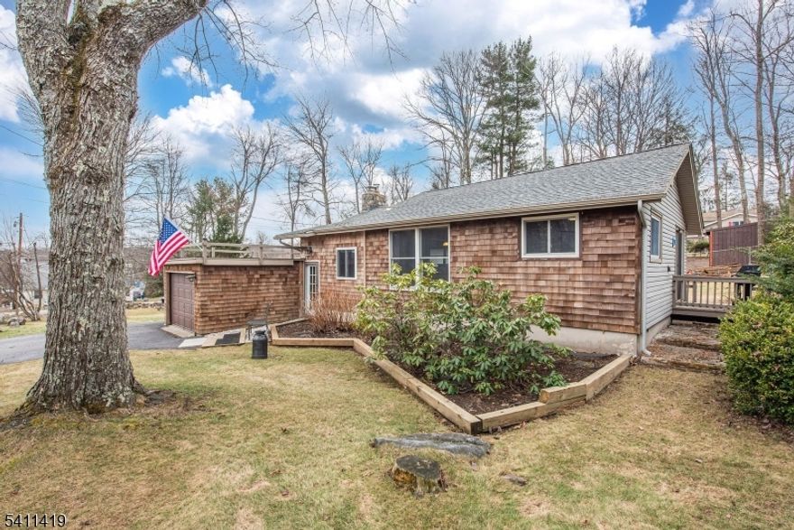 Live the Lake Life in this thoughtfully renovated Ranch with a 1-car garage and fenced backyard, blending rustic charm with modern updates. This inviting home offers 2-3 bedrooms and a tastefully updated full bath, including a super-sized primary bedroom. The modernized kitchen opens to a living room featuring a vaulted, beamed ceiling and an impressive stone fireplace. A formal dining room provides additional space for entertaining.  Additional highlights include a bright, bonus sunroom, main-level laundry, deck, seasonal lakeviews, and a newer septic system.  Plenty of closets.  Easy access attic for extra storage. Room to park your boat!  Outside shed features workshop with electric. Located just a short walk to the Main Lake, this home is part of the members-only Highland Lakes community, offering access to five lakes, seven beaches, a clubhouse, and a wide range of recreational amenities including swimming, boating, fishing, hiking, tennis, basketball, racquet sports, and community events. Conveniently located near Mountain Creek Resort for skiing, snowboarding, and year-round recreation, and less than 50 miles from New York City. Nearby attractions include hiking trails, local wineries, and the Warwick Drive-In Theater.