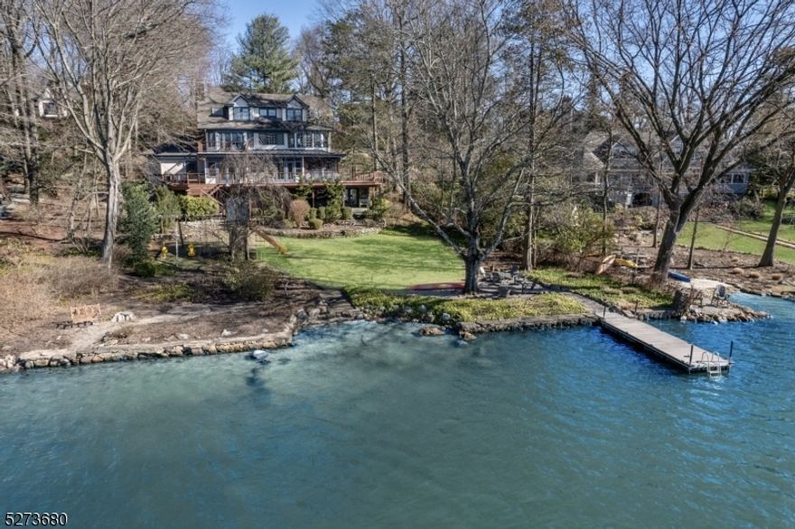 Nestled in the heart of the charming resort community of Mountain Lakes and positioned on the serene side of the MAIN lake, this elegant residence boasts proximity to all 4 schools, the library, post office, Hapgoods, the ML Club, as well as convenient access to the train and bus to NYC.The home's exceptional design showcases soaring ceilings, abundant natural light, and captivating lake vistas from nearly every angle. A rare gem in Mountain Lakes, the property features a level semi-circular driveway, a 2-car attached garage, and a newly added mudroom boasting 6 closets.Entertain with ease on the expansive wraparound deck and screened porch. The gourmet EIK complete with top-of-the-line appliances and a gas fireplace, provides the perfect ambiance for culinary delights. The primary suite, offers a private deck overlooking the lake, a study, 2 walk-in closets, and a spa-like bath. The finished W/O basement boasts a bright recreation room, half bath, storage area, fitness space, and an expansive wine cellar. Additional highlights include a whole-house generator and hot tub. Embrace lakefront living throughout the seasons, indulging in kayaking, paddle boarding, sailing, swimming, fishing and ice-skating. Enjoy breathtaking sunsets year round and 4th of July fireworks! Benefit from the highly regarded Mountain Lakes school district, consistently ranked in the top 10 by Niche magazine. Home being sold "as is".  Transferrable Home Warranty on the property paid for by the seller.