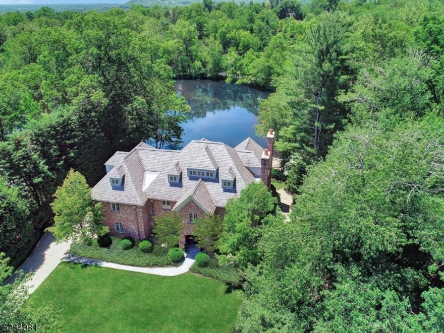 Nestled on the tranquil shores of North Pond, 18 Joanna Way in Short Hills emerges as a pinnacle of luxury and refined living. Imagined by the esteemed John James AIA and meticulously perfected by its current owners, this bespoke residence in Old Short Hills is a true rarity. The home's interior, with its lustrous ebony floors and pristine white walls, presents a spectacular stage for life, art and elegant furnishings. Each room is thoughtfully designed to offer breathtaking water views, adding a layer of serenity to everyday living. The exterior exudes grandeur, featuring a stately slate roof, classic brick facade and lead-coated copper gutters, all complementing a picturesque pea gravel driveway. Inside, the grandeur continues with a soaring three-story circular staircase, encircled by exquisite upgrades like a new gourmet kitchen, a new sumptuous primary bath, a bespoke butler's pantry, a sophisticated library, a functional office nook, an invigorating exercise room and a new state-of-the-art Sonos sound system throughout. The outdoor space, with its expansive bluestone patio and newly added plunge pool, offers a private oasis for relaxing and entertaining. This property is more than a home; it's a testament to luxurious living, where every detail contributes to a harmonious blend of style, comfort and tranquility. Embrace an extraordinary lifestyle and live your waterfront dream every day of the week!