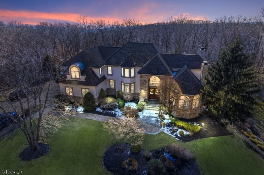 Experience incredible quality blended with breathtaking curb appeal that this home has to offer. Nestled upon Kinnelon's sought after neighborhoods, enter the long private driveway to your very own personal paradise. Sitting on just over 2 acres, this custom-built estate provides a private backdrop with gorgeous mountain and woodland views. As you enter, you are greeted by a detailed, double-story foyer entering into the impressive great room, offering a bright and open living space with a wood-burning fireplace, tray ceilings, oversized windows and cherry built-ins. Also, this space features access to the deck, a separate sitting room and a parlor with a gas fireplace. The first level open floor plan also includes a massive dining room leading to the eat-in kitchen with a center island, breakfast nook and high end chef's appliances, along with access to the 3-car garage, a powder room, laundry/mudroom and maid's quarters. Upstairs you will find four bedrooms and four bathrooms including the huge master suite with spa-like master bath and walk-in closet, two of the bedrooms also include en suite bathrooms. The lower level of the home features a beautifully-detailed wine room, a movie theater, a game room, an exercise room, as well as an office. The lower level walks out to the beautifully landscaped, resort-like backyard, which offers an in-ground salt water pool with a built-in water slide and a swim-up bar. This home is nothing short of perfection!