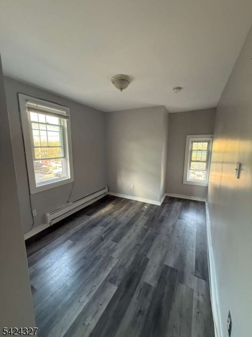 Spacious and move-in ready 3-bedroom, 1-bathroom apartment featuring brand new dark hardwood-style flooring, fresh neutral paint throughout, and plenty of natural light from large double-hung windows.The eat-in kitchen comes equipped with stainless steel appliances including a gas range and full-size refrigerator, wood cabinetry, and a classic tile backsplash. The updated full bathroom offers white subway tile, a tub/shower combo, and elegant marble-look flooring.All bedrooms are generously sized with baseboard heating. A great opportunity in a prime Newark location ? schedule your showing today!*3 BD | 1 BA | $2,300/mo | No parking, laundry, or storage included.*---Ready to copy and paste right into the MLS! Let me know if you'd like any tweaks.