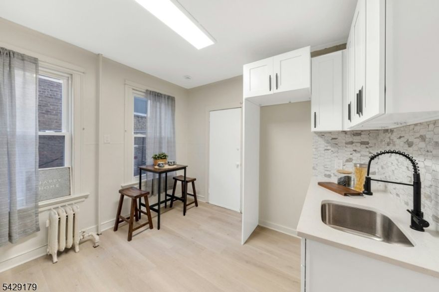 Beautifully and tastefully renovated, this 3 bedroom, 1.5 bath townhouse style brownstone offers exceptional value and true move in ready convenience. No expense was spared in the renovation, blending modern updates with timeless character throughout. The spacious layout features an eat-in kitchen, separate dining area, comfortable living room, and a dedicated office space perfect for working from home or added flexibility. Step outside to enjoy a private backyard ideal for entertaining, relaxing, or everyday use. Conveniently located close to schools, houses of worship, shopping, and major transportation, including direct access to New York City. All renovation work has been completed with permits. A true turnkey opportunity just move your furniture in and enjoy.