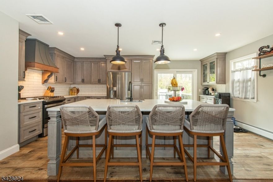 Welcome to a home designed to impress and entertain, inside and out. Step into the heart of the home: a breathtaking open-concept kitchen that's a dream for both everyday cooking and hosting unforgettable gatherings. With sleek modern finishes, custom cabinets with pull out drawers, stainless appliances, a custom hood, generous quartz counter space, subway tiled backsplash and a massive 8 and a half foot center island, making this kitchen a chef's dream!  The lower level has a great size family room, dedicated office, laundry room, and an additional full bathroom. The outdoor spaces are equally captivating. Picture yourself entertaining under the stars by the 3-year-old heated in-ground pool or soaking in the hot tub as laughter fills the air. The expansive new covered patio and outdoor lounge area are perfect for grilling, dining al fresco, or mingling with friends while the large Trex deck provides a scenic spot to unwind with a cocktail or your morning coffee. Recent upgrades also include a newer roof, siding, deck, boiler, water softener, patio, pool, central air and more! Whether it's hosting poolside barbecues, celebrating milestones, or creating cozy memories indoors, this home sets the stage for a lifestyle full of connection and joy. Located on a dead end street, this is more than a home it's where great moments are made.