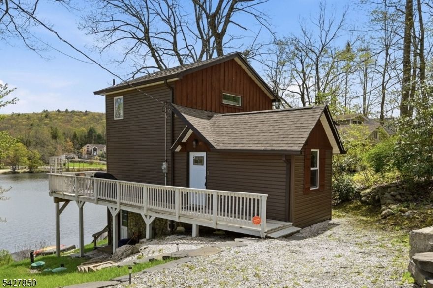 WAKE UP WHERE THE WATER GREETS YOU FIRST! Tucked Into Lake Lookover, This 5yr Young Renovated (2020) 2 Bedroom, 2 Bath Home. Mornings Begin In The Kitchen, Where Soft Eastern Light Spills Through Oversized Windows & The Lake Quietly Reflects Back At You. The Open Living & Dining Space Is Designed To Keep That View Front & Center, Because Here, Nature Is Part Of Your Everyday Routine. A Main Level Bedroom Offers Flexibility For Sleeping Or Work-From-Home, While Upstairs, The Primary Suite Becomes Your Personal Retreat w/Private Bath, Peaceful Views, And Just Enough Stillness To Start The Day. Downstairs, The Walkout Basement With Laundry, Utilities & Rec Area Leads You Outside Where The Property Comes To Life. The Steps Lead You To Your Own Dock Waiting At The Water's Edge. Kayak At Sunrise, Unwind At Sunset, Or Simply Sit & Let The Quiet Do Its Thing. The Deck Off The Kitchen Was Made For Long Summer Nights, Doors Open, Dinner Outside, And Nowhere Else To Be. And Then There Are The Moments You Don't Plan For Fireflies Flickering Over The Water. Fall Colors Wrapping The Lake In Every Shade Imaginable. Whether It's Your Everyday Home Or Your Weekend Reset, This Is The Place That Changes Your Pace Without Asking. Just 8.3 Miles To Route 23. Close Enough For Convenience, Far Enough To Feel Like You've Left Everything Behind. Come See What Life Feels Like Here In West Milford, NJ! Schedule Your Showing Today!
