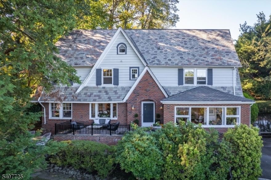 Perched high among the trees with sweeping, unobstructed views of the NYC skyline, this five-bedroom, three full and two half bath home is a rare and breathtaking retreat. With a quiet, castle-like presence, it feels both timeless and deeply connected to its natural surroundings, offering a level of privacy and tranquility that is truly exceptional. Thoughtfully transformed into a picture perfect creative sanctuary, the home is filled with expansive, yet well-proportioned rooms designed for both everyday living and memorable gatherings. Four floors of living in this architectural gem, with massive bedrooms and a flexible lower level that provides space for work, play, and hosting with ease. The true magic unfolds outdoors. The grounds have been lovingly curated into a botanical garden, where winding paths, mature plantings, and seasonal blooms create a sense of discovery at every turn. A charming patio sets the stage for al fresco dining under twinkle lights, while multiple gathering areas invite connection, play and relaxation. Tucked above it all, a private deck offers a spectacular vantage point, an unforgettable setting for morning coffee or evening wine as the city glows in the distance. From sunrise to twilight, the ever-changing skyline view is nothing short of mesmerizing. Whether entertaining or enjoying a quiet moment, this home offers a rare blend of beauty, privacy, and inspiration, just moments from vibrant downtown South Orange, and the energy of New York City.