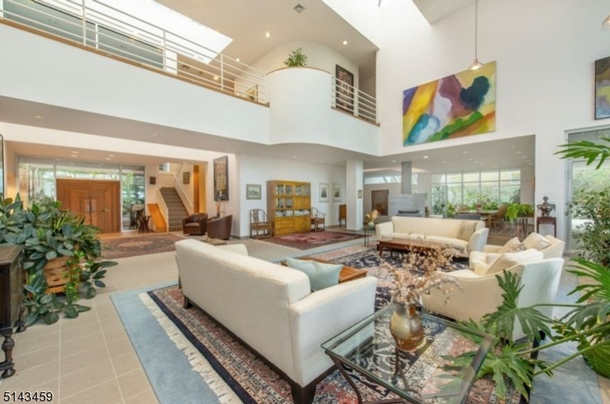 Luxurious CONT interior in this spacious 10,233 sq ft. home with soaring ceilings, walls of glass allowing for sun-soaked rooms, soapstone WDBRN STV, SGDS to BALCS from nearly every richly appointed room. Endless amounts of peace and privacy on over 2 acres of manicured lush grounds wait at the end of a private road. The home accommodates one-floor living with one of 2 MBR suites on the 1st level. The impressive 2nd-floor great room is an entertainer's dream and the 3-story expansive space allows for endless possibilities. The lower level boasts Olympic size length lap pool with a cabana, kitchenette, and full gym. Unique features include a 3 car garage with an electric charging station, whole house generator, and upgraded solar system. Award-winning SCHL SYS. Mins from Manhattan.