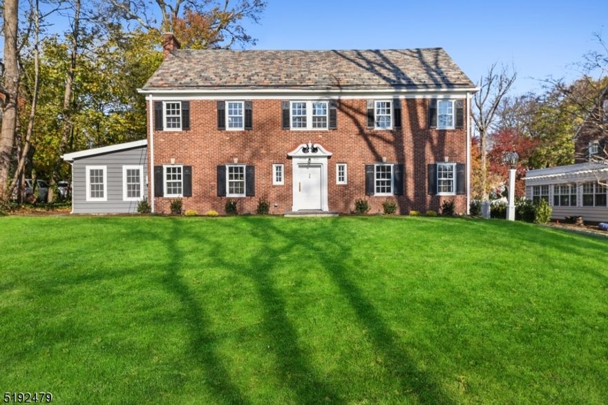 Spectacular brick colonial set in the heart of Maplewood in the premier Roosevelt Park enclave just blocks from vibrant village shops, restaurants, and NYC trains. Fine architectural details and modern amenities blend seamlessly in this very special period home. Welcome guests into a spacious light-filled formal entry foyer with turned staircase, wide openings to adjacent living spaces, and a deep coat closet with a curved doorway. The front-to-back formal living room centers around a fireplace with natural stone details and features period millwork, wide moldings, a built-in bookcase, and views of the yard. A French door opens to a versatile family room with an exposed brick accent wall and access to the patio. A generous eat-in-kitchen with Viking appliances, breakfast bar, and dining area open to the formal dining room. A second staircase provides access to the 2nd-floor bedrooms, including a spacious in-law/nanny suite with a full bath. Two additional hall bedrooms share the hall bath. The primary suite includes an oversized marble bath with a soaking tub, glass-enclosed shower, and double vanity as well as a dressing room/walk-in closet with custom shelving. Upstairs additional bedrooms and a full bath are found. The finished lower level includes a bonus powder room, recreation flex space and laundry. Outside, a large private patio overlooks the sprawling lawns with mature trees and professional landscape.