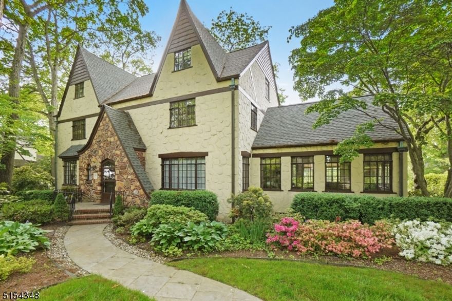 Welcome home to this beautifully updated Tudor home located in one of Summit's most desirable neighborhoods & a short distance to Downtown Summit, Midtown Direct trains, Memorial Field & all schools. Surrounded by lush gardens this grand & spacious home offers approximately 5500 sq. ft. of finished living space on four levels. Upon entering the home you will be amazed by the vast living space. The great room features a beautiful stone fireplace with new gas insert/flue & is adjacent to the stunning sun room. Across the foyer is the formal dining room with built-in corner cabinets & chef's kitchen with granite counters, glass tile backsplash, stainless steel appliances, double wall ovens, multiple prep stations, pantry space & back staircase. The wide sweeping main staircase takes you to the second & third levels. On the second level there are two large bedrooms with Jack & Jill bath & the Primary suite with dressing room, full bath & an additional room for office or closet space. The third floor has two additional large bedrooms with walk-in closets, full bath & storage room. The finished basement features a rec. room, gym, laundry room, half bath, utilities, direct access to level backyard & attached two car garage. Just unpack & enjoy all that Summit has to offer. Interior photos available & showings begin June 9.