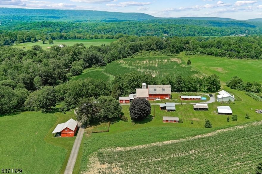 This remarkable 116-acre pastoral FARM includes 2 homes and many out buildings. With over 4,000 feet of scenic water frontage along the Paulinskill River-renowned as one of New Jersey's premier trout fishing destinations- and a picturesque 0.36-acre pond, perfect for fishing, wildlife observation, or relaxing by the water's edge. Enjoy direct access to the Paulinskill Valley Trail, the 6th longest trail in New Jersey, ideal for hiking, horseback riding, and exploring nature year-round.The original 1780 farmhouse is brimming with history and rustic charm, offering 5 bedrooms and 1.5 baths. A spring-fed water source and authentic spring house add to the character. Inside, a spacious walk-up attic is ready to finish to suit your vision. A large barn with a durable slate roof provides ample room for cattle or other agricultural uses. Multiple chicken coops, an oversized Agricultural Steel building, farm equipment storage, and a separate summer kitchen complete the impressive outbuildings.Also included is a three-bedroom, one-bath Colonial home that is income-producing. The land generates additional income from a local farmer and a fishing club, providing revenue sufficient to cover yearly property taxes.This magnificent, once-in-a-lifetime property won't last long. Whether you envision a working farm, private retreat, or outdoor paradise, this special property combines natural beauty, history, and endless possibilities. Call today!