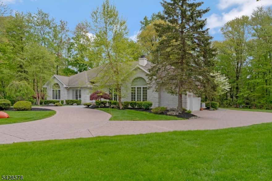 Impeccably maintained custom ranch-style home on a private 2.1-acre cul-de-sac lot. Brick front, circular drive, and professionally landscaped wooded grounds.The center-hall plan supports true one-level living. The first floor includes the primary suite, eat-in kitchen, family room, dining room, living room, and a luxurious laundry room. Hardwood and tile floors, high ceilings, and skylights run throughout. The kitchen features a center island, granite counters, custom cabinetry, and sliders to the deck. The large family room has a tray ceiling and gas fireplace.The first-floor primary suite includes two walk-in closets, a dressing area, and a bath with jetted tub and stall shower. Three additional bedrooms and a full bath complete the main level.The finished walkout lower level expands the living space with a second full kitchen, wet bar, exercise room, oversized rec room, dedicated wine cellar, office area, media room, and full bath. Built for entertaining or extended guests.Systems include three-zone forced-hot-air heat, central A/C, public water and sewer, natural gas, central vacuum, and a built-in 3-car garage with interior entry.Outdoor living is a true strength of this home. A gazebo, deck and patio overlook the private, level rear yard. A built-in wood-fired oven and barbecue anchor the outdoor cooking area.Watchung Hills, Mt. Horeb Elementary, Warren Middle. Convenient to I-78, I-287,  area shopping and dining.