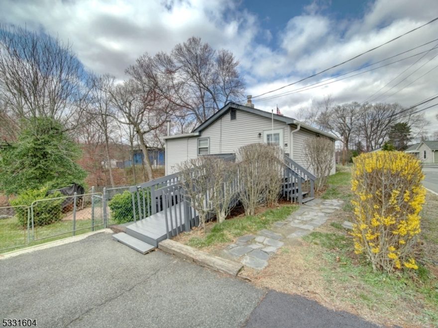 Great opportunity for first time buyers, investment opportunity or purchase over renting. This charming ranch style home is located in the Landing section of Roxbury Township and is very close to marina on Lake Hopatcong. It does have a handicap accessible ramp to front door. This home has three bedrooms, one full bath, eat in kitchen, living room and walk out basement. Basement has wood burning stove, laundry and generous storage areas. There is plenty of parking, including car port, storage shed, and spacious yard with pretty pond view. Great news!....The newer roof was installed in 2023 & there are gas and public sewer hook ups in the street. This home is being sold as is