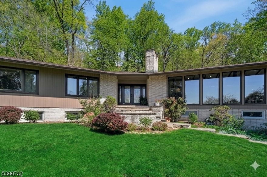 Tucked away on a private 0.57-acre wooded hillside, this 5 BR, 3 BA exceptional mid-century modern home offers a seamless blend of iconic design and resort-inspired living. The sun-filled interior features soaring vaulted ceilings with exposed beams and new 2026 European floor-to-ceiling windows and sliding doors that frame tranquil greenery. The open-concept living and dining areas flow effortlessly, anchored by rich wood accents and elegant architectural detailing. A chef's kitchen with Miele/SubZero appliances and radiant flooring, and newly updated designer bathrooms showcase stone composite tubs and premium finishes. The multi-tiered backyard is an entertainer's dream, complete with an in-ground pool, hot tub and built-in professional-grade outdoor kitchen, and secluded patios. A fully finished lower level with a sauna, recreation room, a full bathroom and 2 guest bedrooms completes this unparalleled sanctuary just moments from top-rated schools and the Mid-Town Direct train.