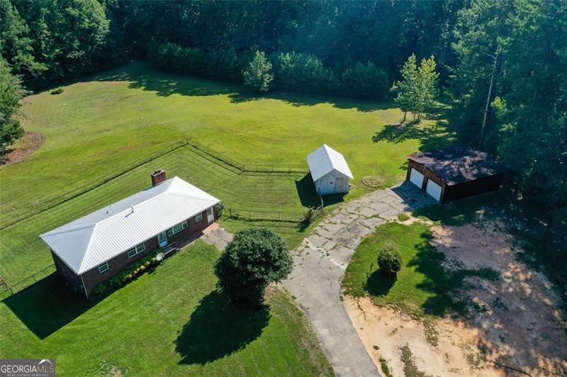 1964 Brick Ranch Home on 10.44 Acres: A Rare Opportunity for Spacious Country Living with Endless Potential! Set on a 10.44-acre canvas of gently rolling land, this classic 1964 brick ranch offers the rare promise of both peaceful country living and exciting future possibilities. With three bedrooms, two bathrooms, a detached two-car garage, and a workshop, this property is ready to welcome a new chapter-whether you envision a beautiful home place, a thriving farm, or a smart investment. For hobbyists and do-it-yourselfers, the detached two-car garage and adjacent workshop are invaluable. Park your vehicles with ease and enjoy a separate, dedicated space for projects, storage, or even a home-based business. The workshop, with power and plenty of room, is a blank slate for woodworking, mechanics, crafting, or equipment storage! The land itself is a highlight! With over 10 acres, the possibilities are nearly endless! For those with vision, the acreage presents an exciting investment opportunity with a possibility of subdividing the land, subject to local planning and zoning regulations. It should be noted that the home does need some cosmetic work. Restore the hardwood floors, refresh the fixtures, and bring new life to the kitchen and baths- this is an opportunity to update and personalize the property according to your own tastes and needs. Situated in a desirable area, the property combines tranquility with easy access to nearby towns, schools, shopping, and services. Don't miss your chance to own this unique property. Whether you see a family homestead, a working farm, or an investment for the future, the possibilities here are as vast as the land itself. Schedule a tour and bring your imagination-your future in this extraordinary place is waiting to begin.