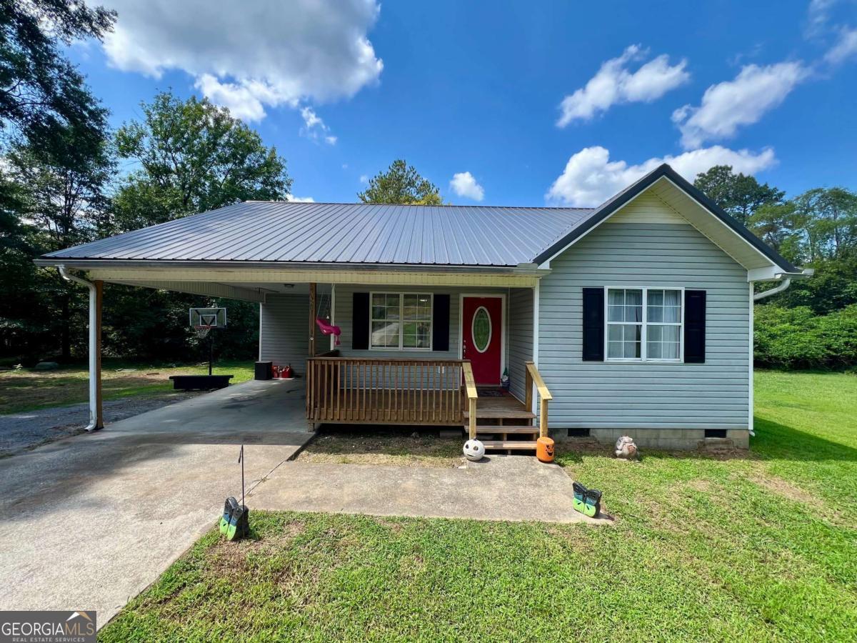 Beautiful 3-bedroom, 2-bath home in a convenient location with easy access to Calhoun, Adairsville, Rome, and I-75. Perfect for first-time home buyers! Enjoy a welcoming country-style covered front porch, ideal for morning coffee or relaxing evenings. The nearly 1-acre lot is just minutes from downtown Plainville and features a carport for covered parking, a small shed for tools, and low-maintenance vinyl siding. Inside, you'll find a spacious living room, an eat-in kitchen with rear deck access for outdoor dining, and gorgeous tile in the kitchen and master bath. Large windows allow natural light to pour in throughout the home. Recent updates include shared bathroom remodel, roof and water heater (2019), and HVAC (2017). Seller is offering a $5,000 credit to be applied toward updates, closing costs, or a rate buy-down. Move-in ready and waiting for its next family!
