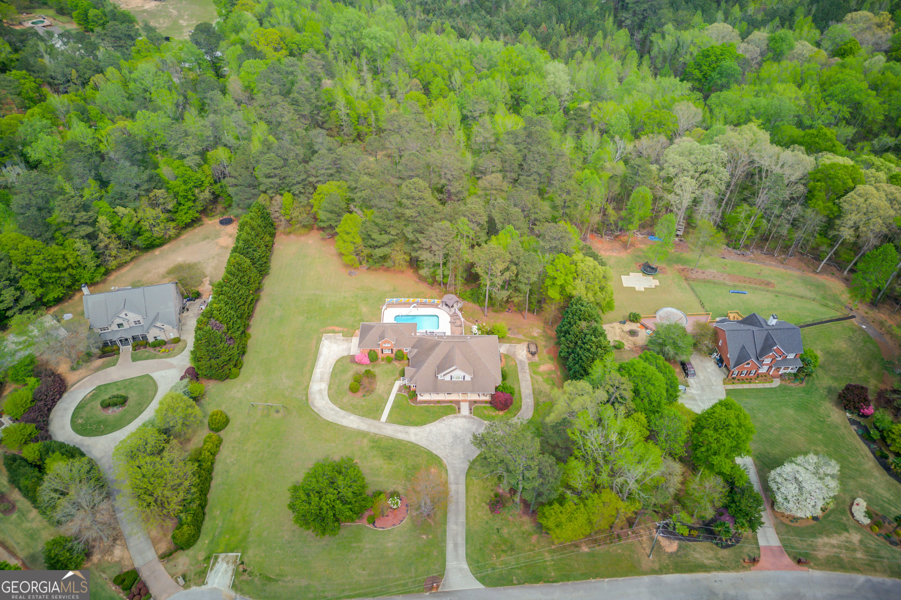 Welcome to your dream home at Windridge Estates! This stunning four-sided brick residence offers everything you could possibly need for both a large family and those who love to entertain. Nestled on 5 picturesque acres, you'll enjoy peaceful mornings with a cup of coffee on the expansive front porch, watching the sunrise, or unwind in the evening from the back porch or sunroom, taking in breathtaking views of the pool as the sun sets. As you step through the foyer, you are greeted by a spacious formal living room featuring a cozy fireplace, creating a perfect gathering space on the main level. Adjacent to the living room, you'll find a beautiful sunroom that brings the outdoors in, and the oversized master suite that overlooks the inviting pool area, offering the perfect retreat at the end of the day. The main level also boasts a large, separate dining room that can easily double as an ideal office space, should you prefer to host meals in the open living area. Conveniently located on the main level, a secondary bedroom with its own en suite bathroom provides an ideal setup for guests or younger children. The heart of the home is the chef's kitchen, an entertainer's dream! It features custom oak cabinetry, a sprawling island with seating that opens seamlessly into the living room, and double ovens framed by an eye-catching brick accent wall. The living room itself is highlighted by a striking two-story stacked stone fireplace, making it a true focal point. Throughout the home, you'll notice an abundance of bay windows that fill the rooms with natural light and offer picturesque views of the surrounding landscape. Upstairs, you'll find two additional spacious bedrooms, a full bathroom, and a walk-in closet so impressive, it's sure to be one of the home's many standout features! The fully finished basement offers a versatile living space that could easily be transformed into a media room or additional entertaining area. The kitchenette is ready to be expanded into a full-sized kitchen, and two generously-sized bedrooms, each with their own en suite bathrooms, provide the perfect space for family or guests. One of the bathrooms is conveniently located right off the pool area, ensuring that wet feet won't track through the rest of the home. The basement also features several finished rooms waiting for your personal touch - think gym, office, or additional bedrooms - the possibilities are endless. Enjoy outdoor living at its finest with a covered patio that is protected by a dry-below system, keeping it dry and usable even when the weather isn't ideal. And, of course, the highlight of the property is the resort-style saltwater pool, surrounded by ample space for entertaining. With a diving board, waterslide, pergola, and raised flower beds that can easily be transformed into additional seating, this is the perfect spot for making lasting summer memories with family and friends. This exceptional home has been meticulously maintained, with recent updates including new pool liner, new HVAC units, water heaters, and pool pump system - just to name a few. Don't miss out on the opportunity to make this your forever home!