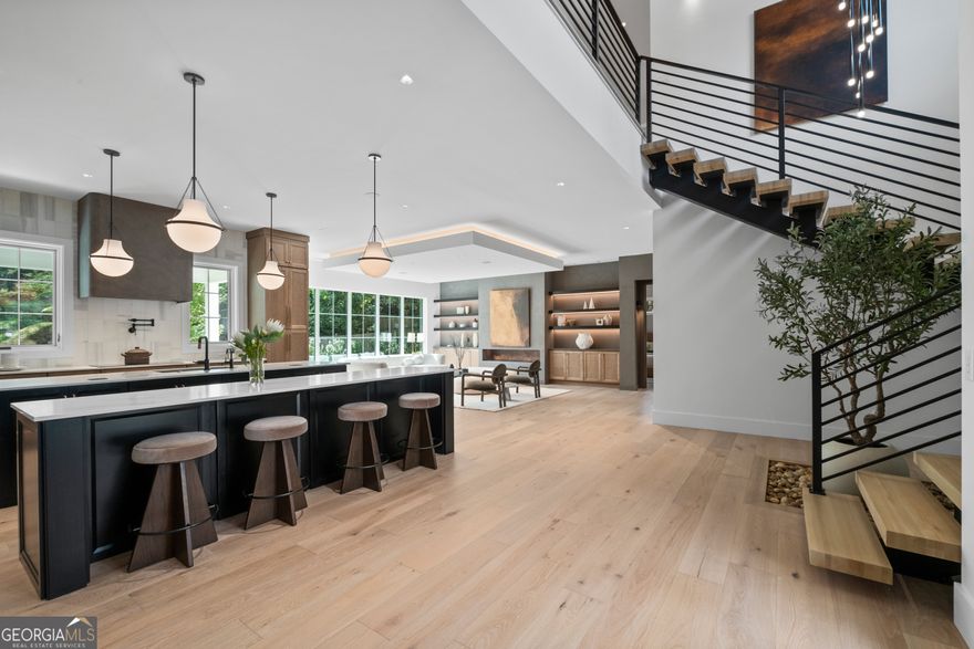 The Modern Farmstead East Cobb reimagines what is possible in Atlanta's luxury home market. The latest custom Earthcraft-certified home built by Kashi Custom Homes, beauty goes beyond skin deep to deliver an unmatched premium, modern living experience in sought after Walton HS district.  It starts with the side entry 3 car garage with space for your full collection, and dedicated charging for 3 EVs. Upon entering, the quietness of this home is apparent, thanks to triple pane Pella windows and well-insulated walls that deliver more than just greater comfort and energy efficiency. The main level open floorplan leads you to the family room, with its custom cloud ceiling, fireplace, and wall of windows. Open to the family room is the oversized professional kitchen with exquisite features including a double island, custom cabinetry, GE Cafe appliances, chef worthy induction cooktop, double ovens, and even a scullery for additional kitchen space.  This top tier kitchen is the life of the home, whether for a week night dinner or hosting a large gathering.  The scullery provides the ultimate prep space for events, even a large pass through window onto the covered porch for enjoying the private backyard. Speaking of outdoor living, head up the rear steps to the roof top deck for even more outdoor entertaining.  When the indoors call, head just inside the massive sliding doors to the second story loft, complete with beautifully designed wet bar area. 4 large bedrooms and 3 full bathrooms round out the 2nd floor.  Head back down to the main floor on the open riser stair case, a stunning feature with its white oak treads and artful chandelier.  A hidden feature is the elevator pit, ready to host a future elevator when needed. Round out the main floor with your primary suite on the main, this quiet refuge will be your spot to rest and relax, from the oversized bedroom, spa-like bath, and spacious closet. A second bedroom on the main plays double duty as a guest suite or home office. This Earthcraft home is loaded with state of the art high-performance, resilient, and renewable energy features designed to deliver an unmatched premium living experience, comfort, healthy air, and low operating cost. Achieve stunning performance and efficiency thanks to induction cooking, Rinnai heat pump water heaters, LG heat pump wash towers in both laundry rooms, a well-designed zoned Trane heat pump with built in dehumidifier and ventilation for fresh comfortable air. Save even more thanks to your very own electricity production via the solar panels on the roof. Resiliency is enhanced by the aesthetic black metal roof for durability, long life, and storm resistance. Being a premium all-electric home with solar, the future homeowner can opt to add battery back up and additional solar for further resilience and energy independence.  This is the home for the discerning buyer who is looking for more than the status quo in Atlanta luxury. Unleash what's possible.