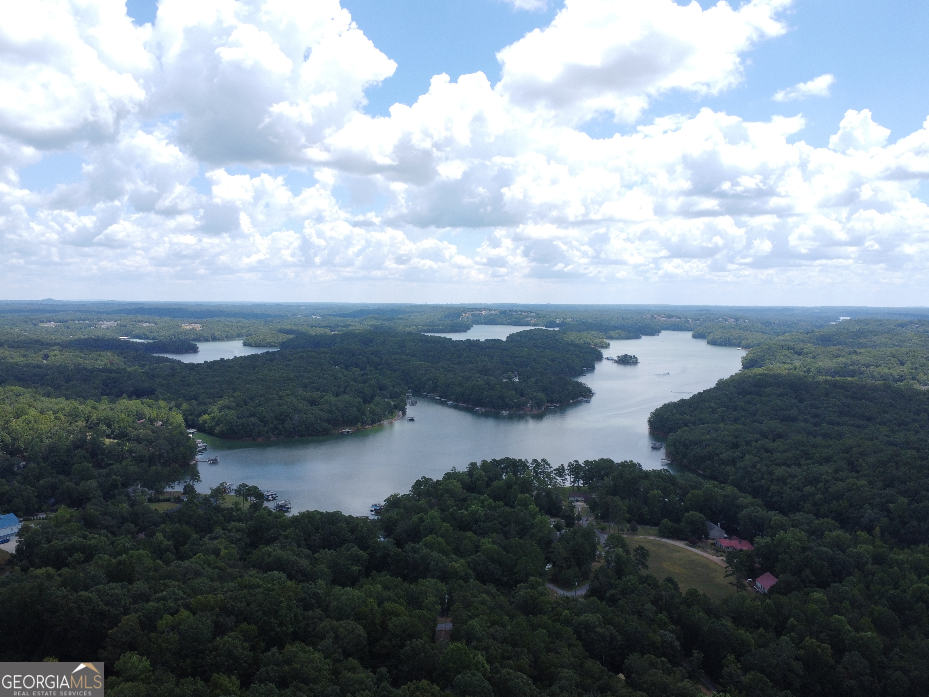 This residential lot offers stunning views of Lake Lanier and is located within a prestigious gated community, providing both privacy and security. Nestled among mature trees and gently rolling terrain, the lot presents an ideal setting for building a custom home that takes full advantage of the lake scenery. Residents enjoy exclusive access to a community courtesy dock. The neighborhood is well-maintained, with paved roads, underground utilities, and attractive homes that enhance the overall appeal of the area. Whether you're looking for a peaceful retreat or a vibrant lakeside lifestyle, this property offers a rare opportunity to build your dream home in a desirable Lake Lanier setting.