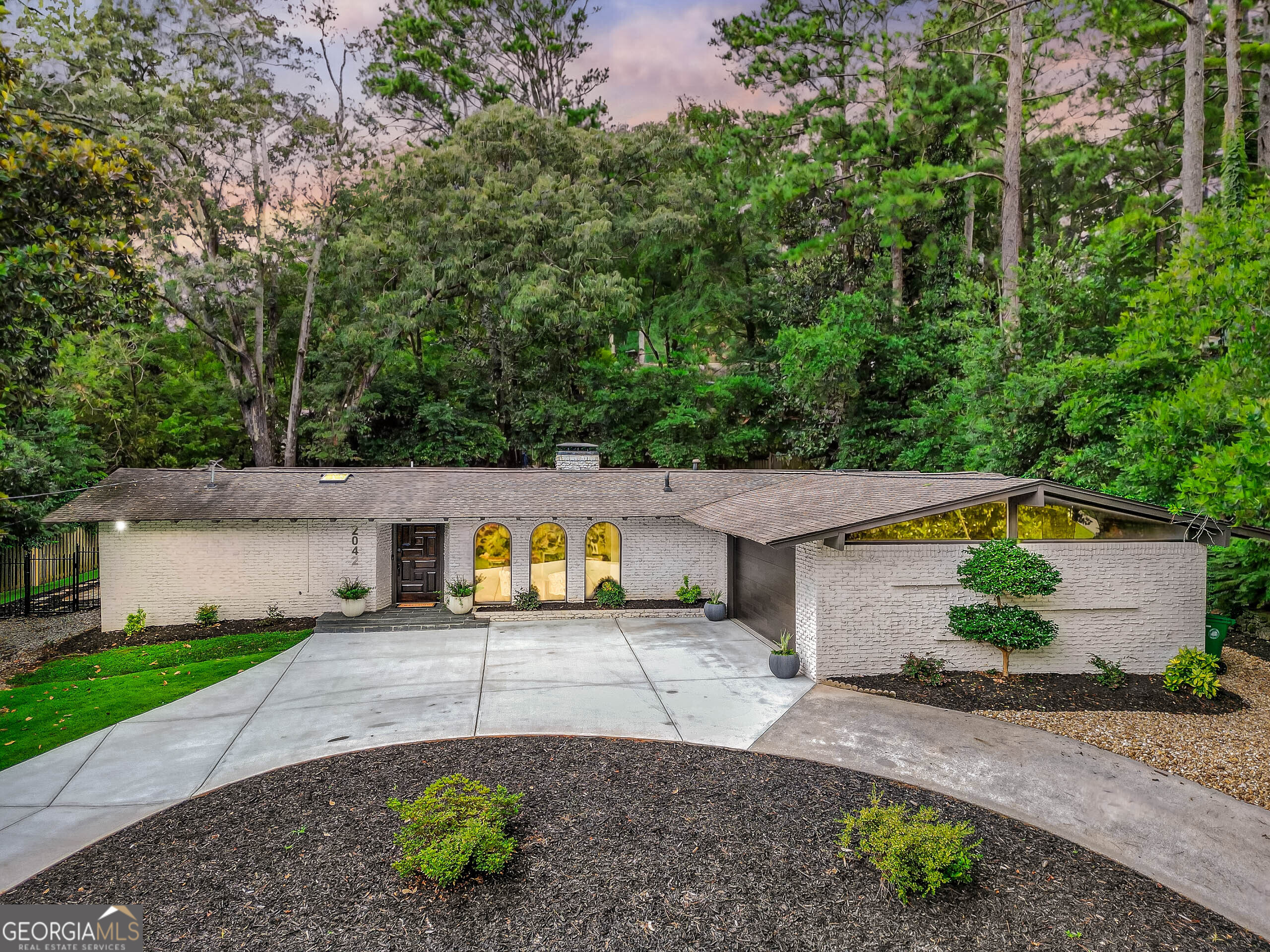 Step into the Mid-Century Modern elegance of this iconic Amberwood retreat. Designed by Robert Green, Frank Lloyd Wright's last apprentice, this one-level, 4-sides brick, Mid-Century-Modern ranch showcases the hallmarks of Green's architectural vision - dramatic natural light pouring through walls of glass and clearstory windows, vaulted ceilings, tongue-and-groove cypress, exposed wood beams, and natural fieldstone. The indoor-outdoor flow is artfully woven into a seamless fabric of color, texture and natural setting. While carefully honoring Green's distinctive aesthetic and Wright's subtle influence, the home has been thoughtfully renovated to incorporate modern comforts and amenities. This offers an expansive central open floor plan highlighted by a separate wet bar, stone fireplace, a wall of glass doors leading to a tiled courtyard, and capped by a designer kitchen curated with premium appliances and sleek finishes. Original cabinetry is found in the former dining room and glass doors meld the gathering area to the courtyard. Baths are spa-inspired, and three separate sleeping areas define spaces. A luxurious owner's suite with private patio is replete with soaking tub, double vanity, and oversized shower. Multiple private patios beckon, providing a serene setting for alfresco dining or quiet contemplation amidst the sounds of nature. An expansive, easy-to-maintain fenced yard offers simple enjoyment, while the circular driveway elevates the home's functionality. Conveniently situated just two blocks from the protected, 21-acre Briarlake Forest Park - an old-growth sanctuary of towering white oak and beech trees. Only minutes to Emory, CDC, Decatur's vibrant dining scene, Oak Grove, major highways, downtown Atlanta, Hartsfield airport and more. Highly regarded schools, of course. Don't miss this rare opportunity to own a piece of Mid-Century Modern history - schedule a personal tour today and experience the timeless appeal of this Amberwood retreat!