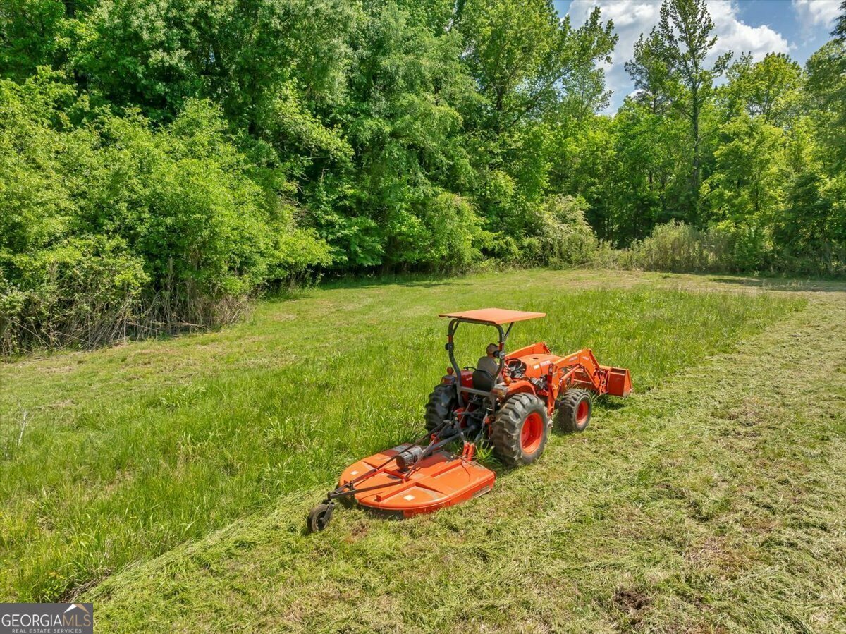 Whether you envision cultivating a single or multi-family homestead this is it! Adorned with a beautiful creek that meanders through the lower 40 acres this 167.86 acres of land has rows of beautiful fruit trees, a variety of hunting options including Dove, Coyote, Deer, and Hog, or you can simply savor the tranquility of rural life and take advantage of the pastures for crops or farm animals. The property neighbors an over 1100-acre Timber farm and backs up to Fort Benning, a premier US Army training base, offering a unique blend of natural beauty, privacy, and security. Approximately 50 acres of the hardwood forest was timber harvested around 15 years ago, presenting an excellent opportunity for future income. Included on the property is a charming 3-bed/2-bath house spanning approximately 1500 sq ft, providing comfortable living quarters along with 3 additional barns, and sheds throughout the property. Conveniently located just 25 minutes from Columbus, GA, you can enjoy easy access to urban amenities while basking in the tranquility of rural living. With its expansive size and diverse terrain, the property holds immense potential for various endeavors.