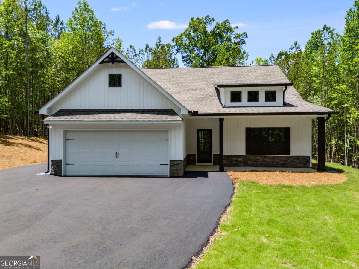 Construction to begin soon! Seize the chance to own your own PRIVATE 10 ACRE lot! This stunning NEW step-less craftsman-style RANCH is designed with modern living in mind! The open floor plan features a vaulted family room with a custom shiplap fireplace. The gourmet kitchen has an oversized ISLAND that is perfect for entertaining & features a charming FARMHOUSE sink. You'll also appreciate the convenience of a separate laundry room & an OVERSIZED PANTRY, providing ample storage and functionality. Every detail exudes luxury and style, making this home inviting and practical. The Gourmet kitchen showcases a CUSTOM ISLAND, FARMHOUSE SINK, STAINLESS APPLIANCES, shaker CABINETS, GRANITE COUNTERTOPS & HUGE PANTRY. The primary suite offers a luxurious ensuite bath with a breathtaking TILE SHOWER & custom glass door, plus a large walk-in closet. Two generous secondary bedrooms provide ample storage with large closets, complemented by a stylish full bathroom. Relax on your picturesque front porch while overlooking your private tree-lined view. The oversized covered back porch is the perfect spot for relaxing & entertaining and features a custom wood-burning OUTDOOR FIREPLACE. This gorgeous modern farmhouse style will include BLACK exterior WINDOWS! Standard features include beautiful exterior vinyl siding, luxury LVP in the kitchen, living room, entry, and baths; plush carpeting in the bedrooms; and high-quality finishes throughout. Enjoy the freedom of a PRIVATE LOT with no HOA restrictions, combining tranquility with convenient access. You still have time to choose your interior and exterior colors to make this home your dream! Not quite the right floor plan or lot? We have other lots and floor plans available! Be sure to inquire about incentives by utilizing our lender, Gareth Thomas, at Silverton Mortgage. Photos are not of the actual home but represent this plan (lot/drone pictures are of the lot).