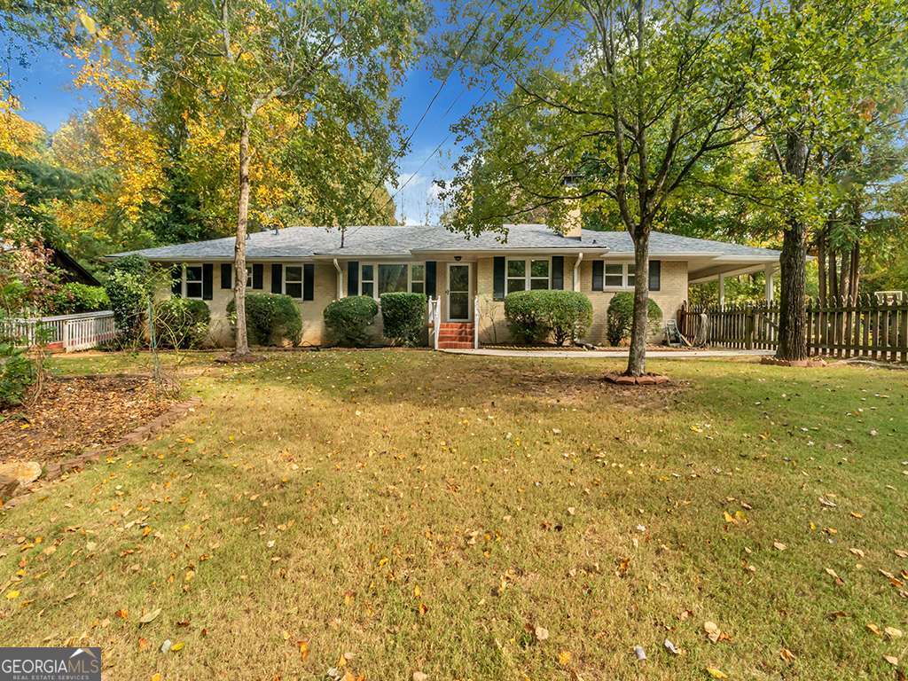 Everything about this City of Dunwoody large 5 bed, 4 bath home on just shy of 1 acre manicured landscaping, is BIG EXCEPT for the rental price. A long concrete drive splits to a covered carport and winds around to a parking pad and garage . This House sits well back from the street to ensure PREMIUM PRIVACY. Presented with two fully equipped kitchens and laundries, the property may be a consideration for the needs of a multi-generational, extended family. Expansive Master bedroom on main with its private external access connects to an exquisitely renovated ensuite with deep soaking tub; main floor bedrooms carpeted, floor areas including two lower bedrooms that are hardwood and/or porcelain tiles. Energy efficient TRIPLE pane insulated glass windows throughout provide quiet and comfort. Walk out daylight lower level with recently installed kitchen and solid quartz countertops completely closed off if needed from the main level. Here are TWO additional rooms with living room and additional laundry on this level . An oversized ( 25ft+) two car, keypad garage and for storage located under the main level from the rear parking pad. Significantly sized, detached workshop equipped with electricity and concrete floor, roller door and external secured door. The workshop can accommodate vehicles and /or repurposed as a separate den/office/storage facility. This is a fully fenced, RING doorbell, pet friendly property with fruit trees and plenty of play space. Landscape maintenance & quarterly pest control is included in the rental. This property is rented as a completely SmokeFee environment. No smoking permitted within the house or on the grounds. Located within 5 minutes of the 100 acre largest park in the region - Brook Run Park with its picnic facilities, skate park, dog park, multi- purpose walking loops, baseball fields and home to youth soccer, flag football, disc golf and Zip-line adventuring. WindWood Hollow and Waterford Parks are close proximity to the home as are Kingsley, Fountainbleau, Deerfield East II, and Spalding Hollow Swim and Tennis clubs. Excellent schools round off this friendly neighborhood.