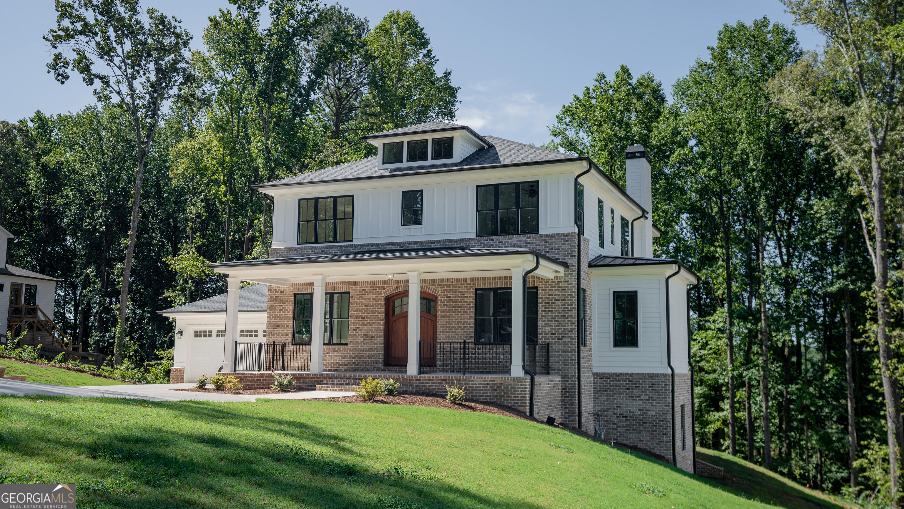 This home is a sanctuary for those with discerning taste seeking to live in a custom home in the rolling hills of Woodstock, Georgia. Set in a private enclave of 5 luxury custom homes, on almost 2 acres, this home is centrally located to Woodstock, Milton, Roswell and minutes from Hickory Flat. Step through the douglas fir entry door and stroll through the coffered ceilings where you are greeted by a chefs kitchen with custom white oak cabinetry that stretches to the 10' ceiling and Cambria countertops with full slab backsplash and under cabinet and toe kick lighting. The centerpiece is a 48" Viking range with paneled viking dish and Jenn Air fridge. The custom cabinetry continues into the pantry with ample prep space and the elegant butler's pantry where guests drinks can be served from a beverage fridge and a prep sink. A thoughtfully placed full primary on main ensures comfort and convenience for guests who are treated to a full ensuite bathroom and shower wrapped in Emser tile. A custom cast stone fireplace surround wraps a gas fireplace in the spacious living space with surround sound for an impromptu dance party. The back porch welcomes and provides the perfect vantage point to enjoy breathtaking views of the rolling pastures and refreshing breezes. Upstairs, the white oak flooring continues in all bedrooms to where each bedroom has a walk in closet and the two front bedrooms share a jack n jill bath. The primary suite is a retreat with a soaking tub and a spacious closet. In the terrace level there is 5.1 surround in both the family room and in the golf simulator/theater room. A home office will fit perfectly overlooking the serenity of the backyard. The wellness room is appointed with an elkay bottle filler and in ceiling speakers. This exceptional home defines luxury and lifestyle, making it the perfect retreat in Woodstock - where every detail has been meticulously crafted for the ultimate living experience. This home was not built as a spec, but as a custom home and then life happens, so it is hitting the market. Too many upgrades to list in a listing description, please schedule a showing today before it is too late. Listing agent related to seller.