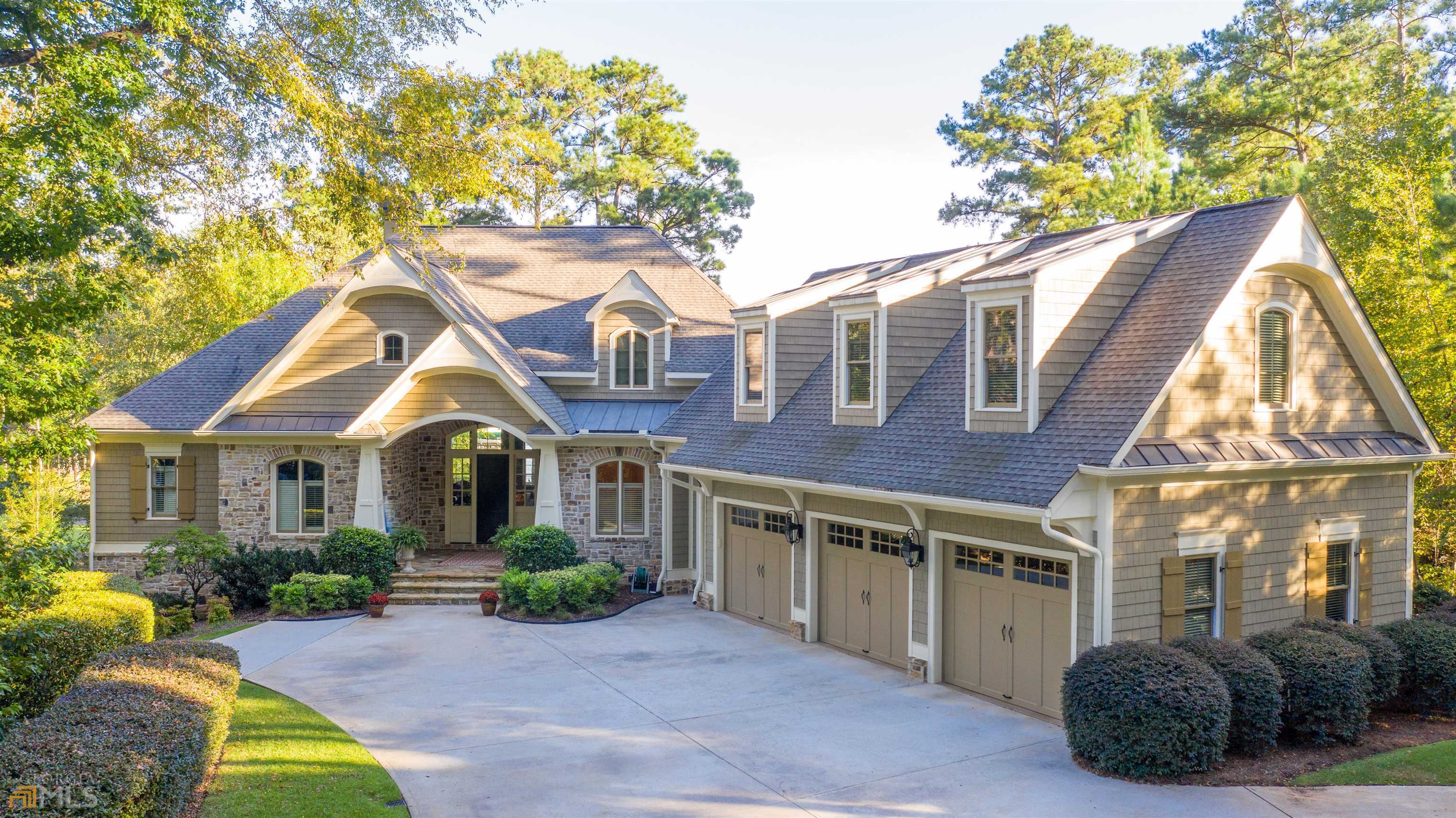 "YOUR PRIVATE LUXURY OASIS WITH STUNNING VIEWS OF THE LAKE AND SUNSET ON A RESORT-STYLE LAKE PROPERTY AT REYNOLDS LAKE OCONEE SITUATED ON A PREMIUM LEVEL LAKE LOT" It is rare to find a magnificent lake home that offers 1.31 acres with water views from nearly every room of the house and every square foot built with the highest quality standard by builder Jim Joel. Beautifully designed, and recently re-decorated, this dynamic home provides many relaxed yet elegant gathering and entertaining spaces. A private long driveway leads to the home and welcomes you with breathtaking lake views presented by the large windows in the great room. The attention to detail is extraordinary with features that include: custom barrel ceiling in the foyer, custom coffered ceiling and limestone fireplace in the great room, dining room with custom bar, gourmet kitchen with a large island, top-of-the-line appliances, adjacent to a lakeview breakfast area, keeping room with cathedral ceiling and unique stone fireplace, gazebo-style screened porch with unobstructed views of the pool and the lake. Wake up every morning to the stunning lake view from the expansive master bedroom with a luxurious master bath. The lower level offers a gorgeous family and recreation room, with custom-designed full bar and wine cellar, three en-suite guest bedrooms and easy access to the stone outdoor patio and amenities. The home offers two offices - one on the main level and another on the terrace level for ease of remote working. A spacious suite is located above the three-car garage. Spend the day soaking in the amazing atmosphere of the outdoors, lounging in the pool and spa, or having a family conversation around the stone fireplace with the breathtaking sunset as your backdrop. Ideally located, you can hop on your boat with your golf clubs to catch a morning tee time at Great Waters, or spend the afternoon on the lake and boat to The Ritz-Carlton or the Lake Club. This is the perfect lake retreat you are looking for! Membership option is available.
