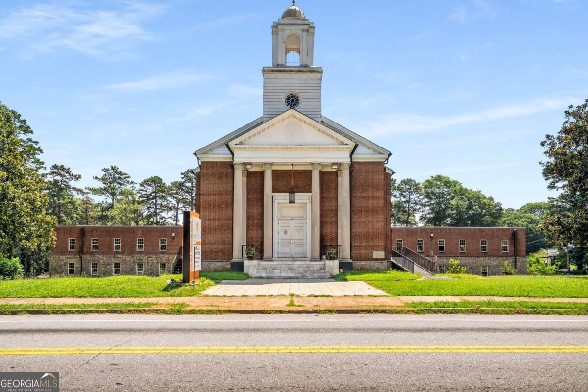 Unlock the potential of this expansive 30,000+ sq ft freestanding building set on over 3 acres in the sought-after Sylvan Hills neighborhood 2 blocks from Perkerson Park and 2 blocks south of the Southside & Southwest Beltline! Currently used as a place of worship, the property offers a full sanctuary with seating for 500+, a balcony level, numerous classrooms and offices, ample restrooms, and generous meeting and fellowship areas. Additional features include a commercial-grade kitchen, a solid concrete basement, and updated flooring in select areas. Currently zoned R4 and located near Opportunity Zones, this versatile space is ideal for a variety of uses- a business headquarters, church facility, production studio, community center, or redevelopment. All of this offers you quick access to GA-166 and just minutes from Tyler Perry Studios, East Point, College Park, and Hartsfield-Jackson Airport, it offers unmatched visibility, convenience, and long-term potential.