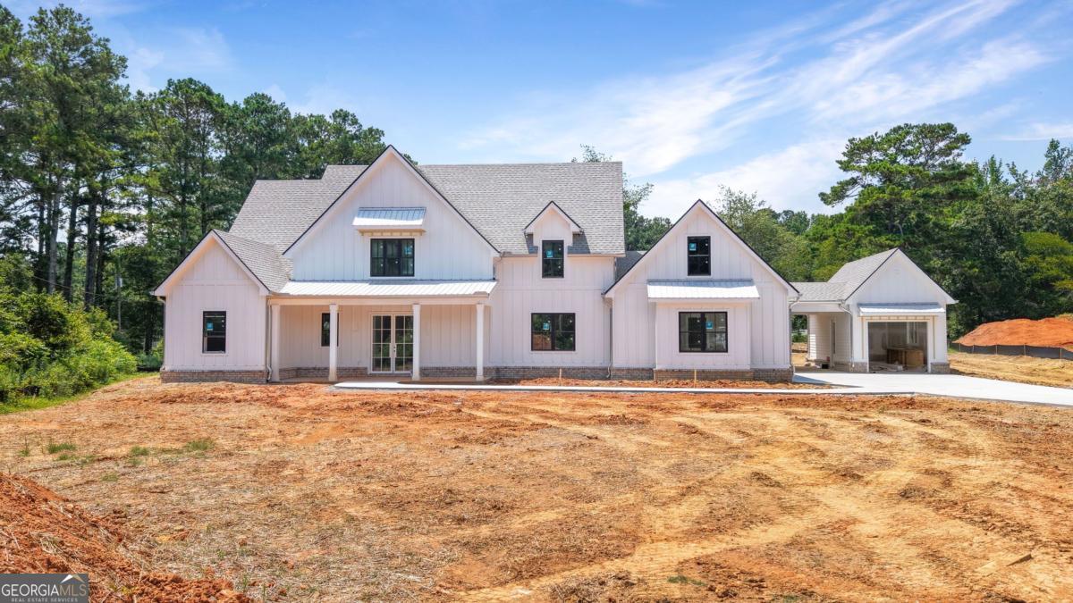 Welcome to this stunning NEW CONSTRUCTION home, nestled on a level and private 0.92-acre lot in an exclusive enclave of just five custom homes in an A+ Woodstock location. With a striking elevation and impeccable curb appeal, this residence offers refined luxury, thoughtful design, and energy-efficient features throughout. Step inside from the covered front porch to a vaulted family room anchored by a beautiful fireplace, featuring custom built-in cabinets and floating shelves on each side. A spectacular 16-foot sliding glass door opens to a spacious covered rear patio with its own cozy fireplace-ideal for entertaining or quiet relaxation while overlooking the private, level backyard, perfectly suited for a future pool. The main level features a luxurious primary suite with a spa-inspired ensuite bath, showcasing a zero-entry shower, designer tile, quartz countertops, and dual custom walk-in closets. A separate guest suite with its own zero-entry bath, a large laundry room, and a well-designed mudroom add everyday convenience. The gourmet kitchen is a showstopper with an oversized island, quartz countertops, a slide-in range, abundant cabinetry, and a separate dining or breakfast room for effortless entertaining. A stunning switchback staircase leads to the second floor, where you'll find two spacious bedrooms, each with its own ensuite bath, and a versatile bonus room perfect for a den, office, or playroom. Built with comfort and efficiency in mind, this home includes spray foam insulation, a tankless water heater, high-efficiency HVAC, and low-maintenance vinyl windows. Every corner reflects quality craftsmanship and luxurious detail-this is Woodstock living at its finest.