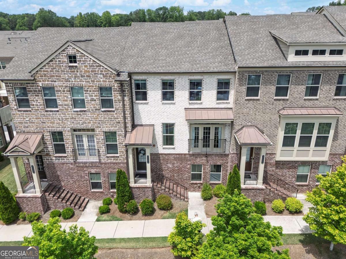 This beautifully crafted Lennar-built townhome is located in the highly desirable Haddonstone community, just minutes from the heart of Downtown Woodstock. With its prime location and thoughtful design, this home offers the perfect blend of comfort, convenience, and style. The main level features rich hardwood floors and an open-concept layout ideal for entertaining. The spacious living room invites relaxation with its stunning view of Kennesaw Mountain, offering a front-row seat to holiday fireworks from the comfort of your home. The kitchen boasts a central island with seating, sleek white cabinetry, stone countertops, and stainless steel appliances, all seamlessly connected to a light-filled dining area and a cozy keeping room complete with a fireplace and built-in shelving. Step outside onto the rear deck, perfect for grilling or unwinding outdoors. A convenient guest bath rounds out the main level. Upstairs, the generous ownerCOs retreat features a tray ceiling, spa-like ensuite bath with double vanity, separate shower, soaking tub, and a walk-in closet. A secondary bedroom with a private adjoining bath offers ideal comfort and privacy for guests or family, and the laundry area is thoughtfully located between the bedrooms for ease of use. The lower level adds even more versatility with a third bedroom currently used as an exercise room, which also works well as a home office, and includes a full bathroom. The home also features a two-car rear-entry garage. Haddonstone is a low-maintenance community where exterior upkeep and landscaping are included, giving you more time to enjoy the neighborhoodCOs amenities, such as the pool and clubhouse. With quick access to I-575 and the express lane, commuting is a breeze. Explore all that Woodstock has to offer, from its charming downtown with shops, restaurants, and entertainment, to the expansive Greenprints Trail system. Discover why this thriving North Georgia town continues to be one of the areaCOs most sought-after places to live.
