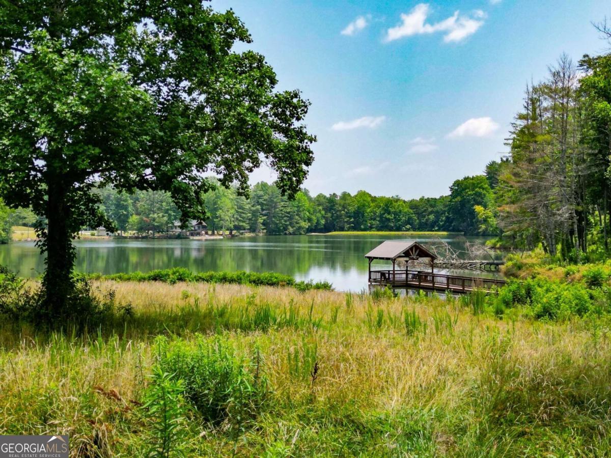 Experience tranquility and exclusivity at Lot 90 in the coveted Yonah Mountain Lake community. Nestled on 1.05 acres, this private wooded lot provides serene views of the community lake. Enjoy the security of gated access, along with amenities such as a fully stocked lake, community pavilion, pier, private beach, and direct trailhead access to Chattahoochee National Forest. Imagine mornings with a peaceful cup of coffee by the lake, afternoons exploring scenic hikes amidst creeks and waterfalls, and evenings unwinding on your secluded back porch enveloped by nature. Embrace the serene lifestyle of Yonah Mountain Lake Co your tranquil retreat awaits.