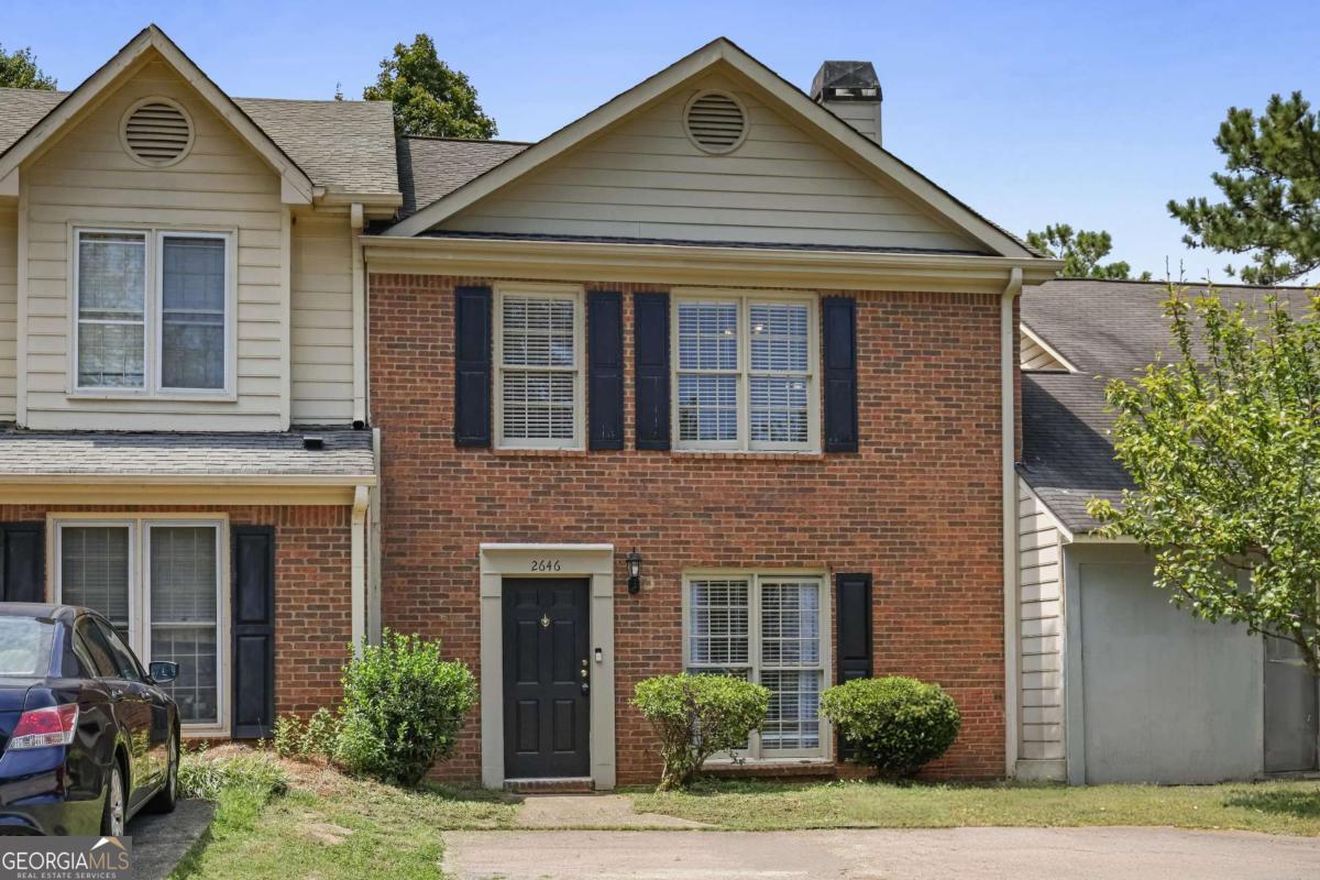 Tucked into a quiet East Cobb neighborhood, this thoughtfully updated 2-bedroom, 2.5-bath townhome blends comfort, light, and modern ease. From the moment you walk in, the home feels open, welcoming, and easy to settle into. Downstairs features durable luxury vinyl flooring, fresh neutral paint, crown molding, and a stone-accented fireplace in the living area-perfect for relaxed evenings. The kitchen offers granite counters, white cabinetry, bar seating, and stainless steel appliances, with an open flow into the dining area and sunny back room. The sunroom is a standout-lined with windows and skylights that pour in natural light, ideal for a reading nook, playroom, or peaceful morning coffee. Upstairs, both bedrooms are spacious with vaulted ceilings and their own private bathrooms. The primary suite bathroom features a beautifully upgraded shower with large-scale tile and glass doors, along with a modern vanity. Private fenced yard, low HOA, and great location close to Sprayberry High School, shopping, dining, and easy access to I-75. This home offers the space and peace you need without the upkeep you don't.