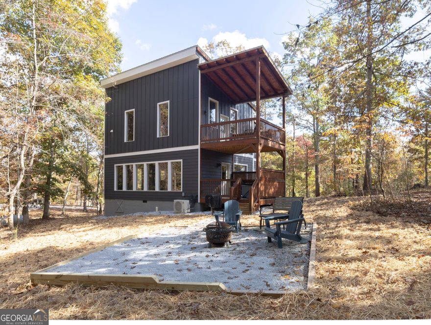 Rare R3 zoning in White County makes the Royal Suite cabin a standout investment, ideally suited for couples or families with small children seeking an escape in a private, spa-like retreat. This nearly-new property offers an upper-level oasis, exclusively designed for relaxation, featuring an $8,000 Jacuzzi Fuzion 2-person spa bath, a cozy private gas fireplace, a walk-in shower with large-format marble-look tile, a personal fridge and coffee area, and a secluded balcony. The main floor boasts an open-concept kitchen and dining area with quartz counters, flowing seamlessly into the living space with a pool table and serene views of mature oak trees. Additional amenities include a private balcony with a hot tub, a firepit area, and an outdoor grill for unforgettable gatherings. Crafted for minimal upkeep, this cabin features durable cement smart siding, luxury vinyl floors, tankless hot water, and timeless all-wood tongue-and-groove walls and ceilings. The rental income continues to grow, with recent September and October earnings reaching $10K. Priced competitively based on nearby comps, the Royal Suite offers years of low-maintenance revenue potential. For a seamless, turnkey experience, the property's current manager-just minutes away-can continue to ensure smooth operations. Make this remarkable investment your own!