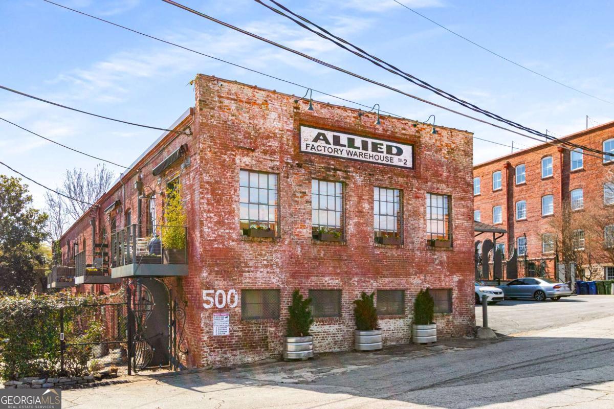 Discover this top-tier loft conversion, perfectly blending historic charm with modern luxury. Designed for both work and play, this expansive space is ideal for entertaining with its soaring ceilings, exposed brick, and period details. Located in a prime area, you can easily walk to GA Tech, Midtown, and West Atlanta. The industrial-chic design showcases original factory hardwoods, crushed marble floors, and reclaimed wood accents, creating a striking and sophisticated aesthetic. Outdoor spaces abound with a huge walkout courtyard and an upper deck offering stunning views of the Atlanta skyline. The chef's kitchen is built for both function and style, featuring an industrial design with stainless steel and integrated appliances, plus a dining space that accommodates twelve. Privacy and security are key, with dual gated parking, two spaces right in front of the door, a second private entry, and an original historic elevator bay. A loading dock is also available for creative art pieces. The versatile living space includes a primary suite with skylights, a private screened porch, and a dedicated laundry room. Additional perks include a private city lookout, gym access, two assigned parking spaces in gated area and a boutique community with only eight units. With over 3,000 square feet of breathtaking space, this is an unmatched opportunity to own a truly unique piece of Atlanta's history-where lifestyle, creativity, and adventure meet.