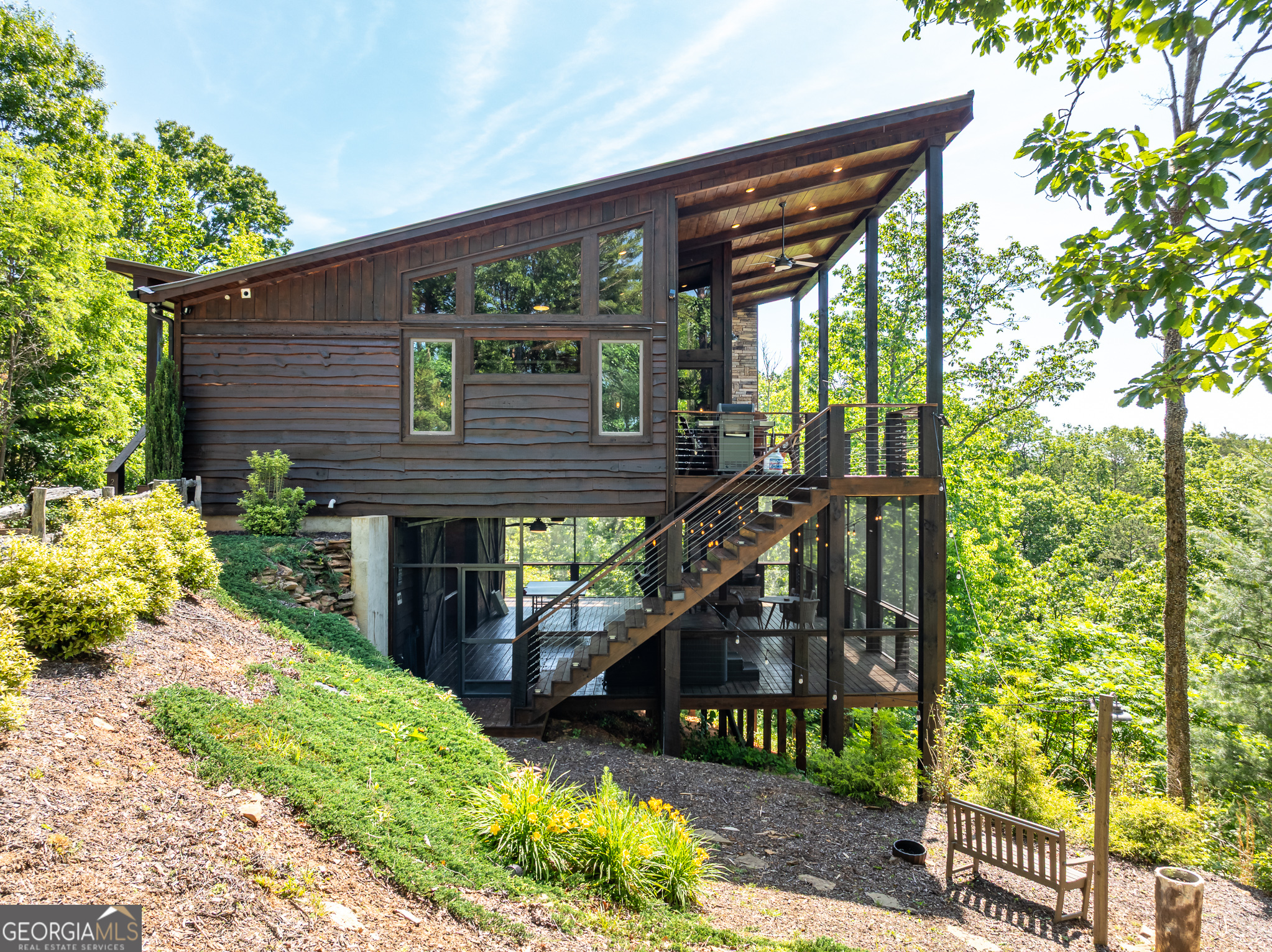 "Chasing Fireflies" is more than just a luxury mountain retreat-it is a top-performing and highly rated short-term rental, booked year after year. Generating over $94k in 2023, $135K in 2024 with a 92% occupancy rate, and fully booked through the end of 2025, this home offers consistency, rave guest reviews, and a loyal base of repeat visitors. Set at a higher elevation just 3 miles from downtown Blue Ridge, the home captures long-range layered mountain views through dramatic walls of glass. The open-concept living room with vaulted ceilings flows seamlessly into the dining area and chef's kitchen, creating the perfect backdrop for entertaining. Two spacious primary suites each provide private retreats, while the lower level offers a lounge and game space that connects directly to the party deck. Outdoor living defines Chasing Fireflies, with two covered decks, dual outdoor fireplaces, a hot tub, and gathering spaces positioned to showcase the panoramic views. The exterior was freshly stained in 2025, and a private well was installed in 2023-two major updates that protect the property's value and reduce future maintenance. Offered fully furnished and under professional management, the property is a proven, income-generating business with a strong reputation and future bookings already secured. This is a rare opportunity to step into one of North Georgia's most sought-after vacation rentals, backed by performance, recognition, and unparalleled mountain views.