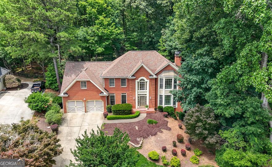 Welcome to your move-in ready home in the highly rated Pope High School district. From the moment you arrive, you'll be greeted by a beautifully landscaped exterior dotted with ornamental Japanese Maple trees and a private backyard-ideal for outdoor living, gardening, or relaxing under the trees. Step inside to a bright, welcoming two-story foyer with hardwoods, fresh paint and brand-new carpet throughout. Just off the foyer, the formal living and dining rooms create the perfect setting for gatherings and everyday living. The spacious upper level features a large owner's suite with a charming bay window, a relaxing tub, separate shower, and a generous walk-in closet. Two additional bedrooms share a hall bath with a double vanity. A secondary staircase at the back of the home offers a convenient connection from the kitchen area to a fourth bedroom with its own private bath, providing the ideal space for guests, teens, or a home office. Need more room to grow? The full daylight, unfinished basement offers incredible potential-create a gym, playroom, workshop, or additional living space, all while still having plenty of storage. Out back, enjoy year-round outdoor living with a partially covered deck featuring both a screened-in porch and an open-air area-perfect for morning coffee or dinner under the stars. This is the one you've been waiting for-fresh, flexible, and full of possibility in a community you'll love calling home.