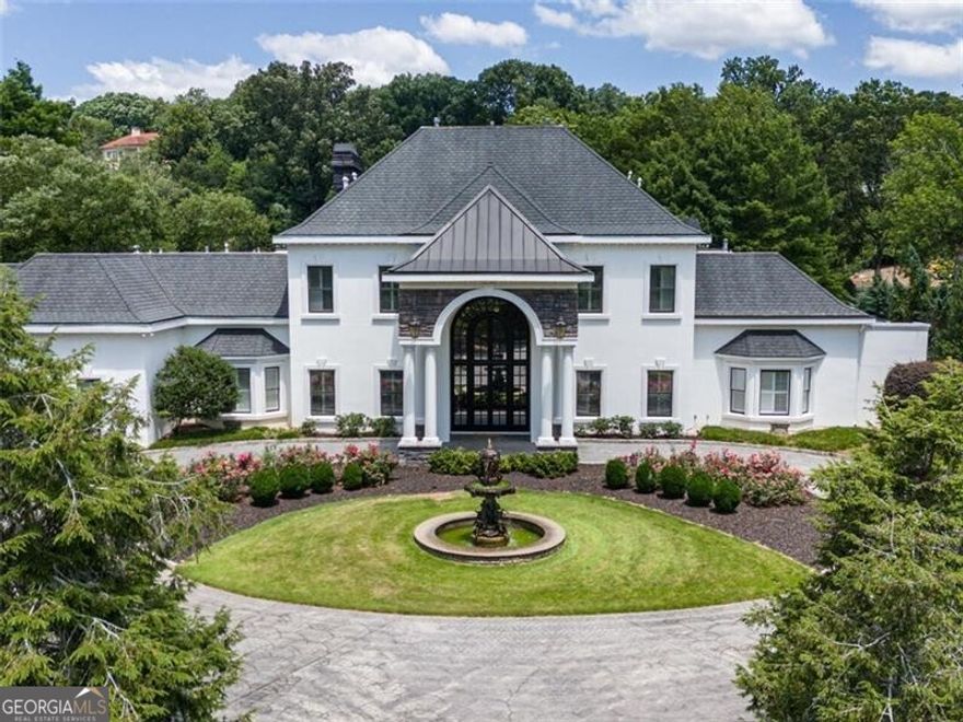 Price improvement AND new custom steel exterior doors to be installed in December to bring a fresh, modern aesthetic to the home (9 sets arched patio doors and front entry). Step into another world of privacy and luxury nestled on almost 8 acres minutes from the city center. Residing on coveted Columns Drive, this former equestrian estate across from the Chattahoochee River is an oasis like no other. Magnificently manicured grounds create a tranquil, park like setting equipped with a 5 stall barn,5 pastures, paddock, large private pond with fountain & dock, walking trail, salt water pool/spa, tennis court, playground, gazebo and greenhouse. The 2 story carriage house(currently a workshop) with full finished bath and 2 car garage can easily be converted into an office/studio/Airbnb/caretaker's cottage and is accessible by a separate gated service entrance to the property. This remarkable residence has been updated to today's living standards, exuding a blend of traditional and modern architectural elements throughout. Relax in your luxurious master suite conveniently located on the main level. The stunning staircase leads to 4 generously sized bedrooms on the East wing with all walk in closets and large ensuite baths. The West wind has 2 spacious options for an au pair or in-law suite along with laundry and direct access to the back staircase. The 3rd floor bonus room is equipped with a full bar and half bath, providing endless possibilities for a game room, theatre, or additional entertaining. Renovated with discerning taste and quality, this home was designed for hosting large gatherings. The fabulous white chef's kitchen with new Italian marble and hardwood floors also has a separate butler's pantry/prep station with a fully equipped walk in pantry. Beautiful arched French doors surround the entire pool/spa area where you can unwind overlooking the fabulous pond and hear nothing but the sounds of nature. Imagine taking a morning stroll around the lake as you watch the sunrise or relax on your dock in the evening. Maybe evening slip your kayak in the water for a leisurely paddle. This fully sustainable estate has smart home features, new roof installed 8/2025, highly efficient newer HVACs, new tankless water heaters, pool with new tile surround, Tesla chargers, and a large generator more than sufficient to power all buildings on the property. The residence is fully fenced with 2 gated entrances for added convenience. This remarkable property is one of a kind and sure to impress! Low Cobb taxes, Sope Creek, Dickerson, Walton schools with quick access to the state Chattahoochee River Park for hiking, biking, walking and kayaking. Agents please see private remarks prior to scheduling a showing.