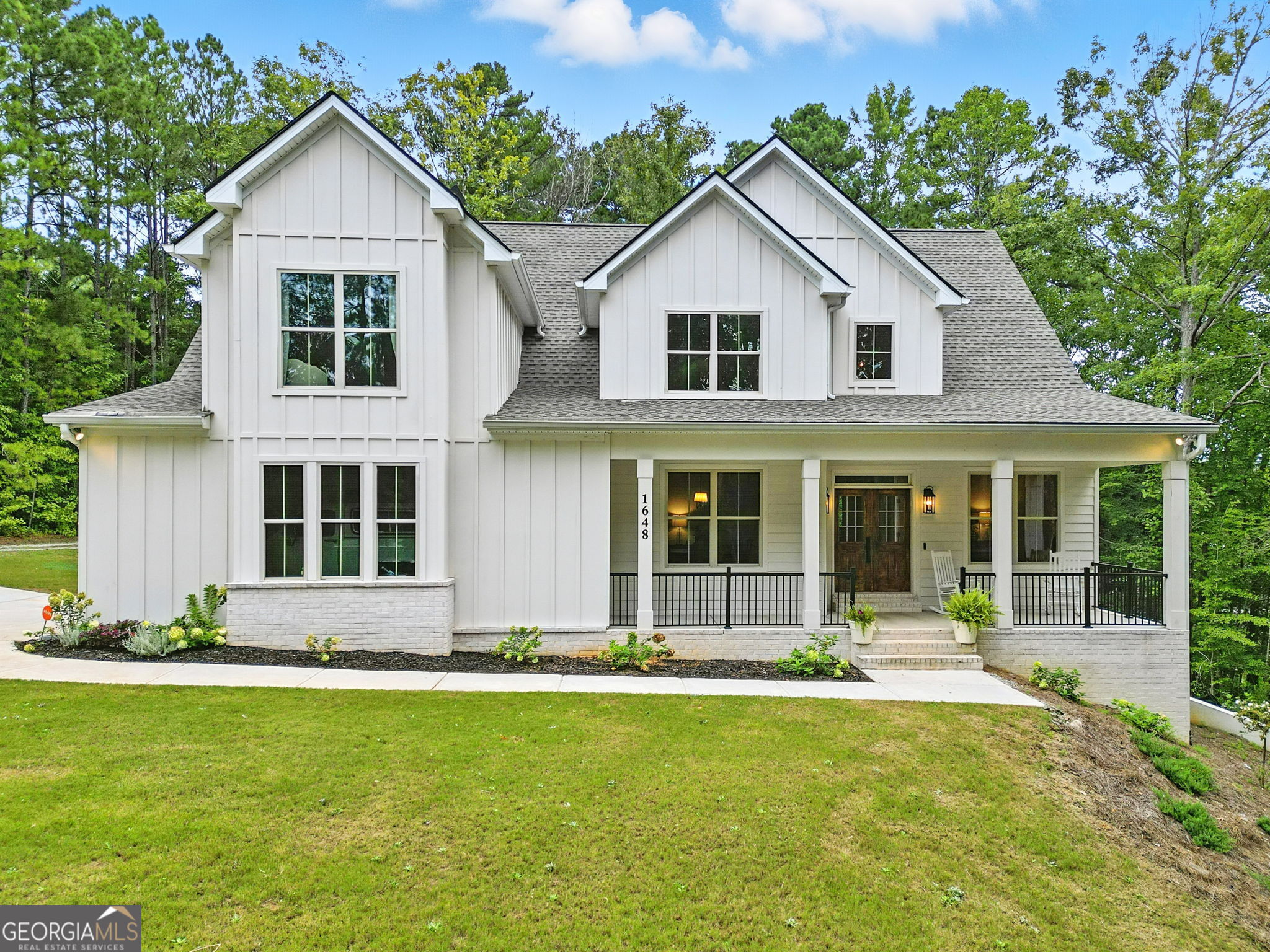 Welcome to your dream modern farmhouse retreat! Nestled on a serene 1 acre lot, this stunning 4 bedroom, 3.5 bath, full walkout basement home blends sophisticated elegance and cozy old world charm throughout. Built in 2022, this 3,066 sf residence boasts an open concept layout with designer qualities and flair, clean lines, warm tones, arched doorways, soaring ceilings, executive level trim, hardwood laminates on the main level, and abundant natural light streaming throughout. The heart of the home is the bright and airy kitchen with a fresh and timeless appeal featuring a sprawling 9 ft. quartz island, ample custom shaker soft close cabinetry, stainless steel appliances including a double oven, decorative shelving and hood vent, farmhouse sink, and large walk-in pantry. Just near is the breakfast nook overlooking a tranquil backyard set amidst lush Georgia hard woods and pines. Adjacent, the large living area centers around a custom cast stone Euro decorative fireplace, high peaked ceilings, and a wall of rear facing windows framing a gently sloping backyard. The main floor primary suite is roomy and offers a spa-inspired bathroom with a freestanding soaking tub, dual vanities with upgraded faucets, an arched walk-in rain shower, walk-in closet, plus convenient direct outdoor access via a sizable covered porch- an inviting spot for morning coffee or reading time. The main floor also features a welcoming double door entryway, double French doors leading to flex space ideal for an office or den, a spacious and inviting formal dining room, a half bath, decorative hall alcove with storage, and laundry room with wash basin. Upstairs and providing ample room for family or guests, are three spacious bedrooms with wall accents adding a pop of style, two full baths, and a versatile bonus room ideal for a play area or media space. Outside, the private backyard includes a large covered porch, play structure for children, and plenty of space for a pool. Throughout this lovely home, you'll find carefully chosen upgraded lighting fixtures that blend style and function, elevating every space. Additional highlights include alarm system, and prewiring for intercom. This modern farmhouse is more than a home- it's a lifestyle. While offering the ultimate secluded setting, it's surrounded by top-rated schools, restaurants, shopping, parks, walking trails, a local library, and vibrant community events. This serene retreat offers the perfect balance of rural charm and modern convenience. Schedule your visit today!