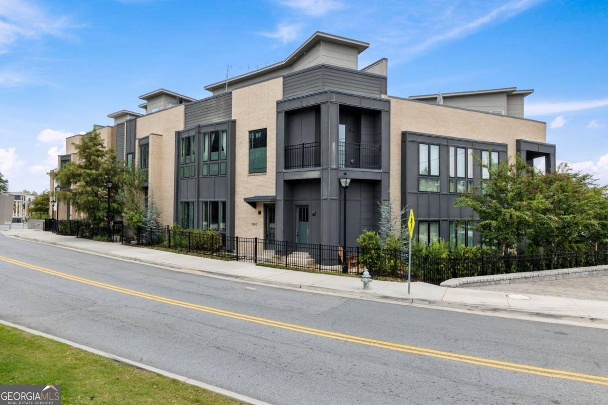 Flagship residence in the heart of Downtown Chamblee, custom-built by the community's developer as his personal home. This 4 bed/4 bath townhome is truly one-of-a-kind with soaring 12' ceilings, expansive windows, and unique architecture that creates generous living spaces throughout. Custom features include a rooftop deck with interior wet bar, private courtyard with designer landscaping, coffee bar lounge & balcony off the primary suite, waterfall kitchen island with wire-cut terra cotta tile feature wall, wide-plank hardwoods, custom lighting & draperies, mudroom with wine storage, and elevator-ready shaft. A Sonos system throughout the entire residence turns your home into a personal entertainment experience. Step outside your front door where you can easily access the vibrant city of Chamblee from your own private fenced in garden and courtyard. Enjoy the ultimate urban oasis just steps from shops, dining, and entertainment-an opportunity in a class of its own. Step through the front door and into a world where modern design meets effortless sophistication. The main floor welcomes you with an open flow that blends kitchen, living, and dining spaces into one seamless experience. The chef's kitchen is a showpiece-complete with a walk-in pantry, waterfall island, and designer finishes that reflect both craftsmanship and creativity. Just beyond, the living room invites conversation beneath soaring ceilings and sunlit windows, while the dining area sets the stage for intimate dinners or lively gatherings. Also on this level, a full bath and a versatile bedroom with its own private entry offer flexible possibilities-ideal as a guest suite or a chic home office. Ascend the staircase to the primary suite level, where the tone shifts from lively to serene. The oversized owner's retreat is bathed in natural light from expansive city-view windows, and features a custom walk-in closet designed for both style and function. The spa-inspired bath invites indulgence with double vanities, double shower heads, a private water closet, and luxury finishes that exude calm modern luxury. A private sitting room with a wet bar creates a perfect morning coffee lounge or evening retreat, opening to a private balcony overlooking Downtown Chamblee's skyline. On this same level, a secondary bedroom with an en suite bath and a convenient laundry room make daily life effortless and organized. Venture to the top level, where entertainment takes center stage. The loft with a wet bar leads to a spectacular rooftop patio-a true urban oasis. Here, you'll find both open-air lounging and a covered area with a mounted television, ideal for al fresco gatherings, sunset cocktails, or late-night jazz under the stars. Downstairs, the terrace level offers yet another layer of versatility. A mudroom welcomes you from the two-car garage, alongside dry wine storage, and a bedroom with a private en suite bath-perfect for guests, a media suite, or a quiet retreat. From the sunlit main floor to the skyline views above, every level of this townhome tells a story of thoughtful design and refined living-a true flagship residence in the heart of Downtown Chamblee. Every detail of this exceptional residence tells a story of vision, craftsmanship, and elevated living. From its thoughtful architecture to its curated finishes and skyline views, 2142 Bristol Cove embodies the essence of modern Chamblee life - vibrant, walkable, and effortlessly sophisticated. Whether you're entertaining on the rooftop, unwinding on your private balcony, or enjoying quiet moments in the designer kitchen, this home offers an experience that feels both luxurious and personal. Steps from Chamblee's best dining, shopping, and entertainment, it's the perfect blend of urban energy and refined comfort. Don't miss your chance to own the flagship home of this sought-after community - a residence that's truly in a class of its own.