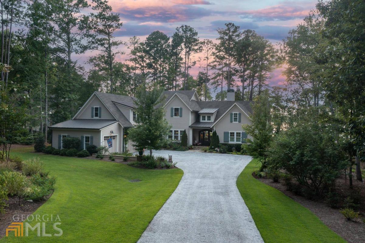 "STUNNING CUSTOM LAKEFRONT HOME WITH REFINED OUTDOOR LIVING IN REYNOLDS LAKE OCONEE" Welcome to this incredible custom home by one of Lake Oconee's premiere builders, DreamBuilt Homes, featuring over 4,900 square feet, 5 bedrooms, 3.5 baths on over 1.5 acres with 210' of shoreline creating a rare park-like level lake backyard with magnificent sunset views. Built in 2018, this home is the definition of "custom." Every detail, convenience, and comfort has been incorporated into a luxurious, relaxed space perfect for entertaining. The living room with 12" plank pine flooring overlooks the pool, beautifully landscaped yard and lake, and adjoins the unique dining room with custom banquette seating and 12' cabinet for serving, and shiplap walls. The kitchen is a Chef's dream with custom cabinets (each drawer with dividers) marble countertops, Sub-Zero 36" refrigerator with two freezer drawers, Sub-Zero undercounter refrigerator drawers, Wolf convection oven and steam oven, 36" Wolf warming drawers, 48" Wolf sealed burner range, Asko dishwasher, two separate full-size sinks, and a custom towel drying inset. In the wide hallway behind the kitchen you will find additional cabinets that house small appliances and pantry items. The hallway, with its beautiful slate floors, encompasses the half bath which is near the porch for easy access from the lake/pool, office, laundry room/bar area with outside access, study, and elevator. The master bedroom has serene lake views, double walk-in custom closets, and large master bath with heated floors. The second story features three spacious bedrooms, two full bathrooms, large craft room with custom built-ins. The outdoor setting is simply majestic with an 18x32 PebbleTec heated saltwater pool with 2' travertine coping and automatic cover built in 2021. The covered porch provides a gorgeous setting overlooking the pool, a beautiful peninsula, firepit, private max dock, and sandy beach area perfect for paddle boards. Take your golf cart to the dock along the path composed of durable, low-maintenance shredded tires. Outside storage room provides the perfect place to store lake gear. Other features include custom stone driveway with large parking area, handicap-accessible doorways, Hunter Douglas electric blinds, plantation shutters, Lutron light switches, huge walk-in attic for storage, extra-large 3-car garage, fresh water source at dock, and low-voltage landscape lighting. Membership is available.