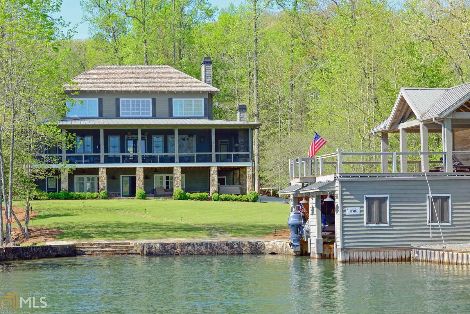 This 6BR, 6.5ba Lake Burton home rests on a level fee simple lot with a direct view of Billy Goat Island and the July 4th fireworks. The clean-lined interior is reminiscent of a modern coastal farmhouse with a touch of antique class. The light-filled great room features a stone fireplace, antique beams and shiplap paneling that provide for casual and comfortable lake living. The glamorous chef’s kitchen was designed with entertaining in mind and includes a butler’s pantry that opens to the oversized lakeside screened porch that runs the length of the home. Features include: 2 master suites on main, oversized 2-car garage, terrace level family and rec room with billiards, ping pong and shuffle board, hot tub, lakefront stone patio, 2-story boathouse.