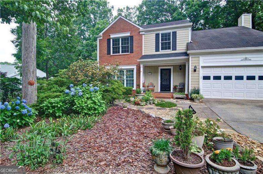 Absolutely charming, meticulously maintained home with upgrades galore!  From the beautifully landscaped front entrance and the stunning mahogany & leaded glass door to its private, wooded back yard, this home has it all!  Tall ceilings and great natural light create an open, airy feel. There is an abundance of space for relaxing and entertaining on the main level with separate living and dining rooms, great room and cheerful sunroom.  The updated kitchen boasts plenty of storage space, an island & a breakfast bar, a stainless steel refrigerator, modern lighting and beautiful light maple cabinetry. Upstairs the master suite features a vaulted ceiling, dual closets and sinks and stone counters.  There are three additional bedrooms and a conveniently located laundry as well.  The gardens have been lovingly nurtured and the large tree filled back yard provides a private oasis with its firepit and expansive seating area. Additional features include a level lot, leaf guards on gutters, double pane vinyl windows, under counter kitchen lighting, gas fireplace  and SMART thermostats. This swim/tennis neighborhood is in an excellent school district and is close to schools, shopping, restaurants, Marietta Square and access to the National Kennesaw Mountain Park. Priced to sell!