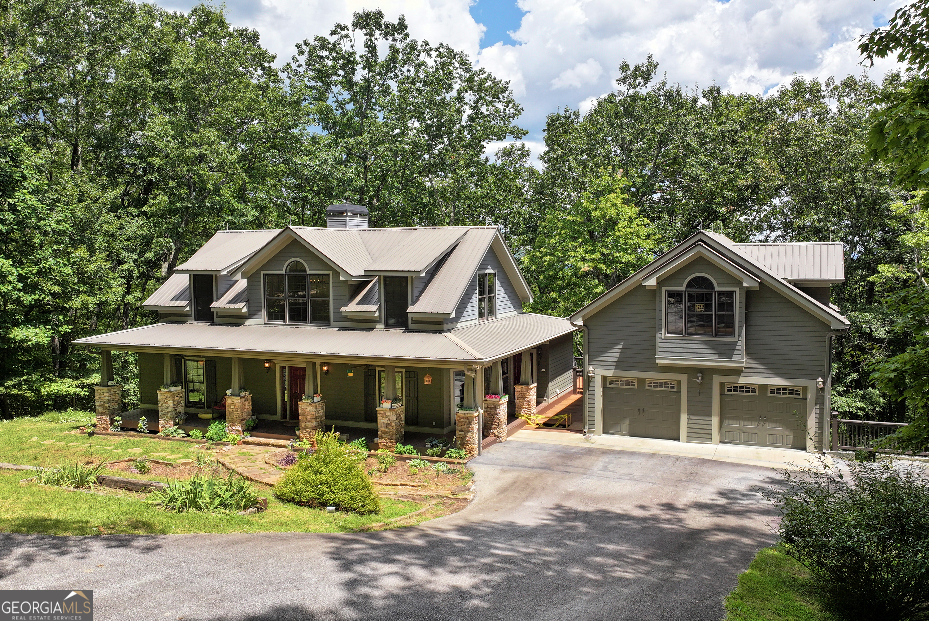 Welcome to 873 Laurel Ridge Road, a beautifully updated mountain retreat on 15.46 private acres atop Yonah Mountain, surrounded by over 1,000 acres of protected forest. Just minutes from downtown Helen, this property offers privacy, peace, and flexibility as a primary home, second home, or income-producing STR or long-term rental. The main house features a 2-story entry and great room with a soaring stacked-stone fireplace. The spacious kitchen includes granite countertops, white cabinetry, a farmhouse sink, 5-burner gas range, tile backsplash, and room for an L-shaped island. Adjacent are a breakfast room and a screened-in porch overlooking the hot tub and wooded views. The main-level primary suite includes access to the deck, his-and-her closets with custom shelving, and a beautifully tiled ensuite with a double vanity and double-head shower. Also on the main floor: an office with built-in cabinetry, half bath, laundry room, and wood floors throughout. Upstairs are two bedrooms, each with double walk-in closets, a shared bath with double vanity, walk-in shower, and more hardwood floors. The walk-out basement is unfinished but air-conditioned, with a workshop area and a reinforced concrete "bunker-style" storage room. The detached temp controlled 2-car garage includes a carriage house above with its own power, water, and septic-featuring a living area, full bath with shower, and closet. A generator supports the main level of the home, and high-speed fiber internet ensures you're always connected. The property is gated, with a paved driveway and no HOA-just simple road maintenance. Don't miss this unique opportunity to own a fully modernized mountain escape with unmatched privacy and income potential.