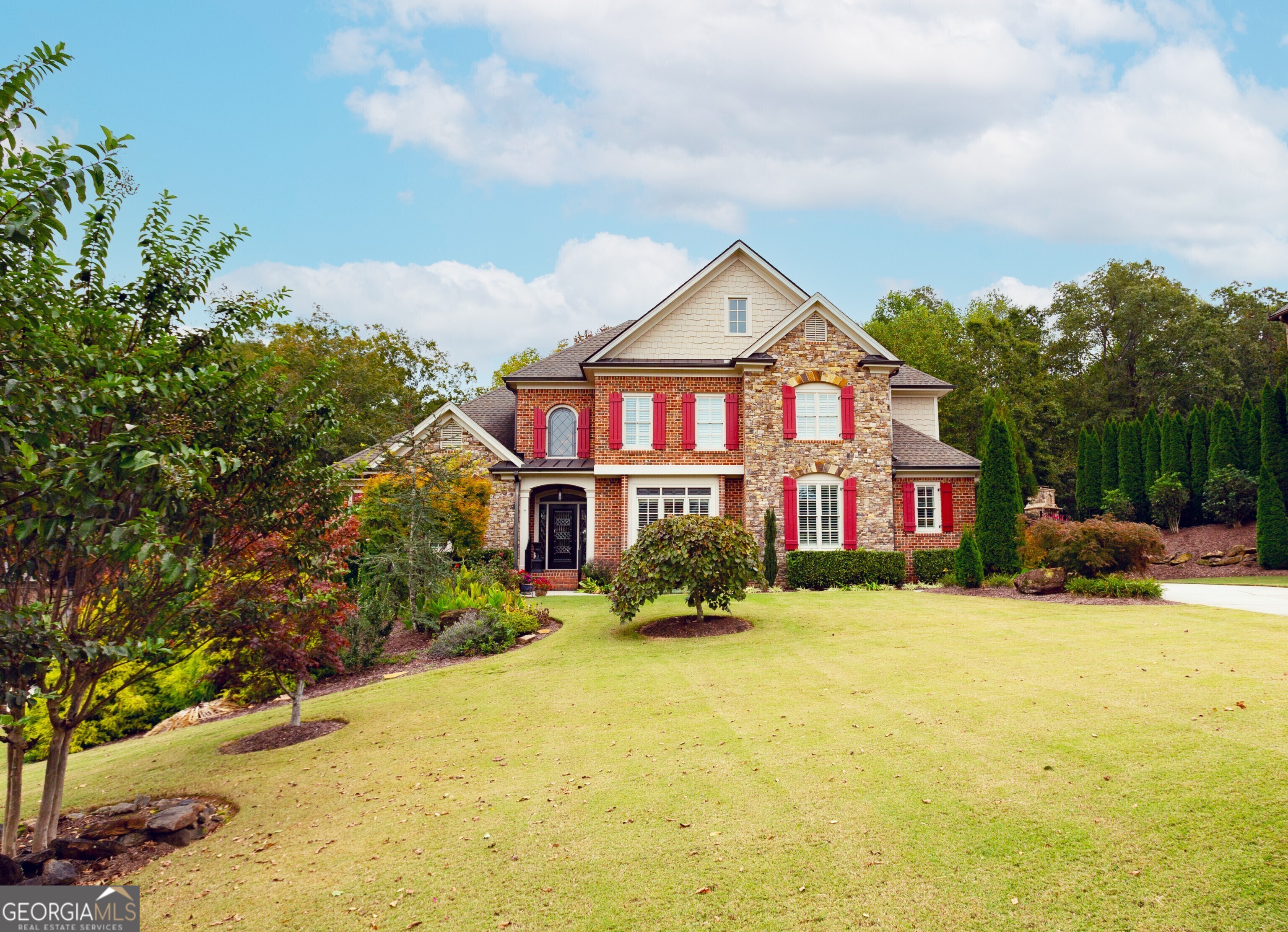 Don't miss out on this new listing in sought-after neighborhood in Forsyth County! This custom-built home has so much to offer and incredible curb appeal. As you walk into the 2-story foyer, you have a formal dining room to the right, ahead of you an inviting formal living room with high coffer ceilings, large windows with natural light overlooking the stunning .72 acre lot that has been meticulously maintained. The oversized owner's suite located on the main level, with tray ceilings, double vanities, separate tub and shower, and great walk-in closet. The chef-style kitchen has an oversized island, gas cooking, and tons of storage with a great pantry, overlooking the keeping room with beam ceilings, custom built-ins, rock fireplace, separate breakfast area and a large screen in porch to relax. Off of the kitchen you will find laundry room and mud room that opens to a three-car garage. On the second level you will find 3 nice size additional bedrooms and 2 full baths. A loft that can be used for an office, media room or an additional bedroom. The unfinished basement is waiting for someone's personal touch with exterior entrance. This home is great for entertaining. Cool Springs Subdivision are high level homes with a Community Pool and Two Tennis Courts. Only 5 minutes from GA 400, Hwy 369, and new retail developments. Excellent Award-Winning Forsyth County Schools!