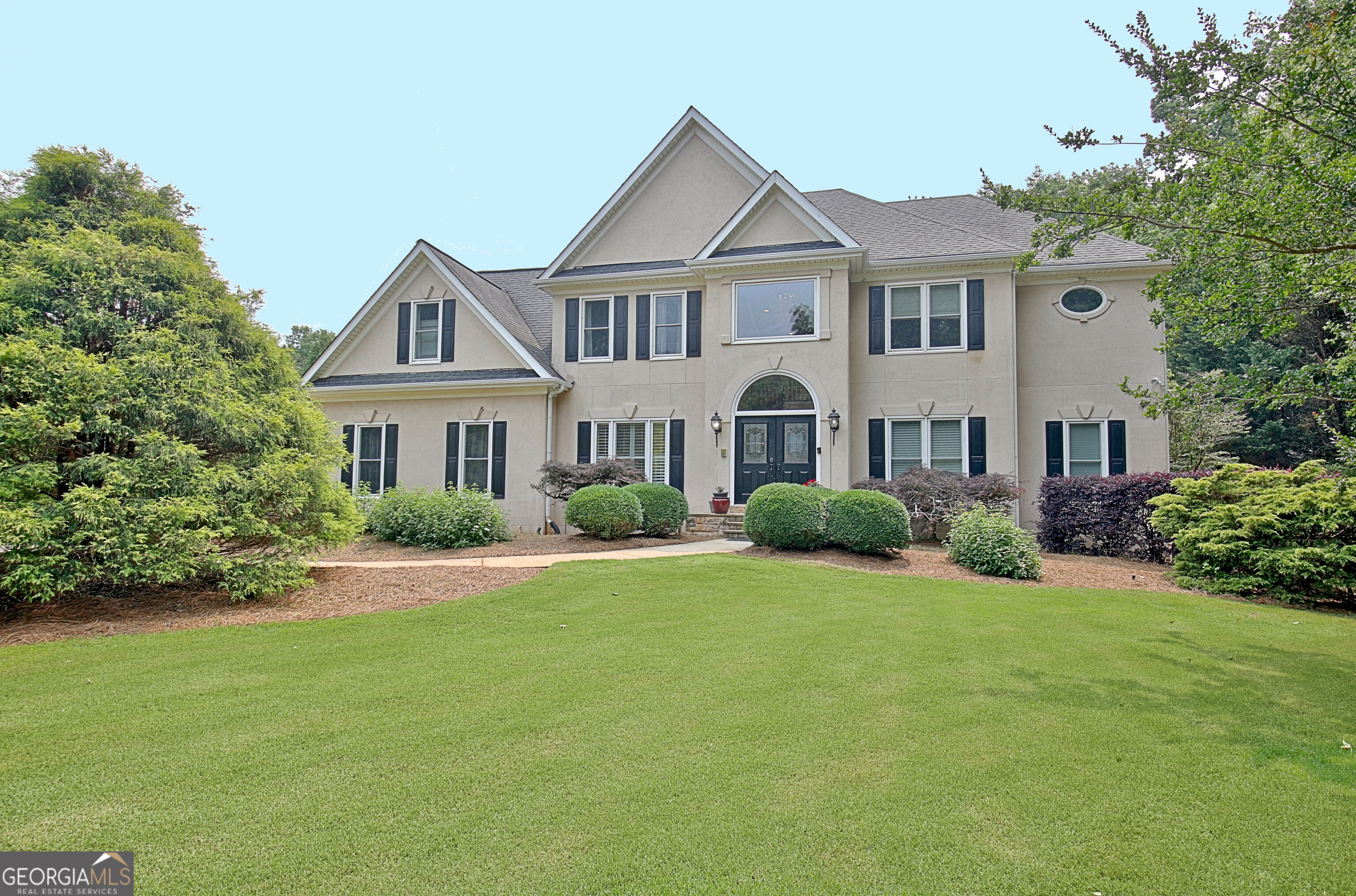 This beautiful home is designed for luxurious living, with a stunning back yard that feels like your own secluded sanctuary resort. Situated on a quiet street with a cul de sac, this elegant Smokerise home welcomes you through the grand foyer to its open spacious layout, with high vaulted ceilings, large living spaces, and high end lighting and design features throughout. The primary suite, conveniently on the main level, offers a luxurious spa-like en suite with marble counters, a stylish soaking tub, separate shower, and a large custom closet. Upstairs are four bedrooms with newly renovated baths, and an open loft perfect for reading and relaxing. The finished terrace level features another bedroom suite, a workout room, and great entertainment space, including game room, built in bar, and full kitchen! But the piece de resistance is the 900 sq. ft. screened deck with dramatically high vaulted ceilings, stone fireplaces, and outdoor kitchen overlooking the showstopper pool - possibly the largest in Peachtree City - surrounded by lush gardens, beautiful brick patios, a cozy firepit and gorgeous stonework. This is truly a special property in an amazing location. A Must-See for sure!