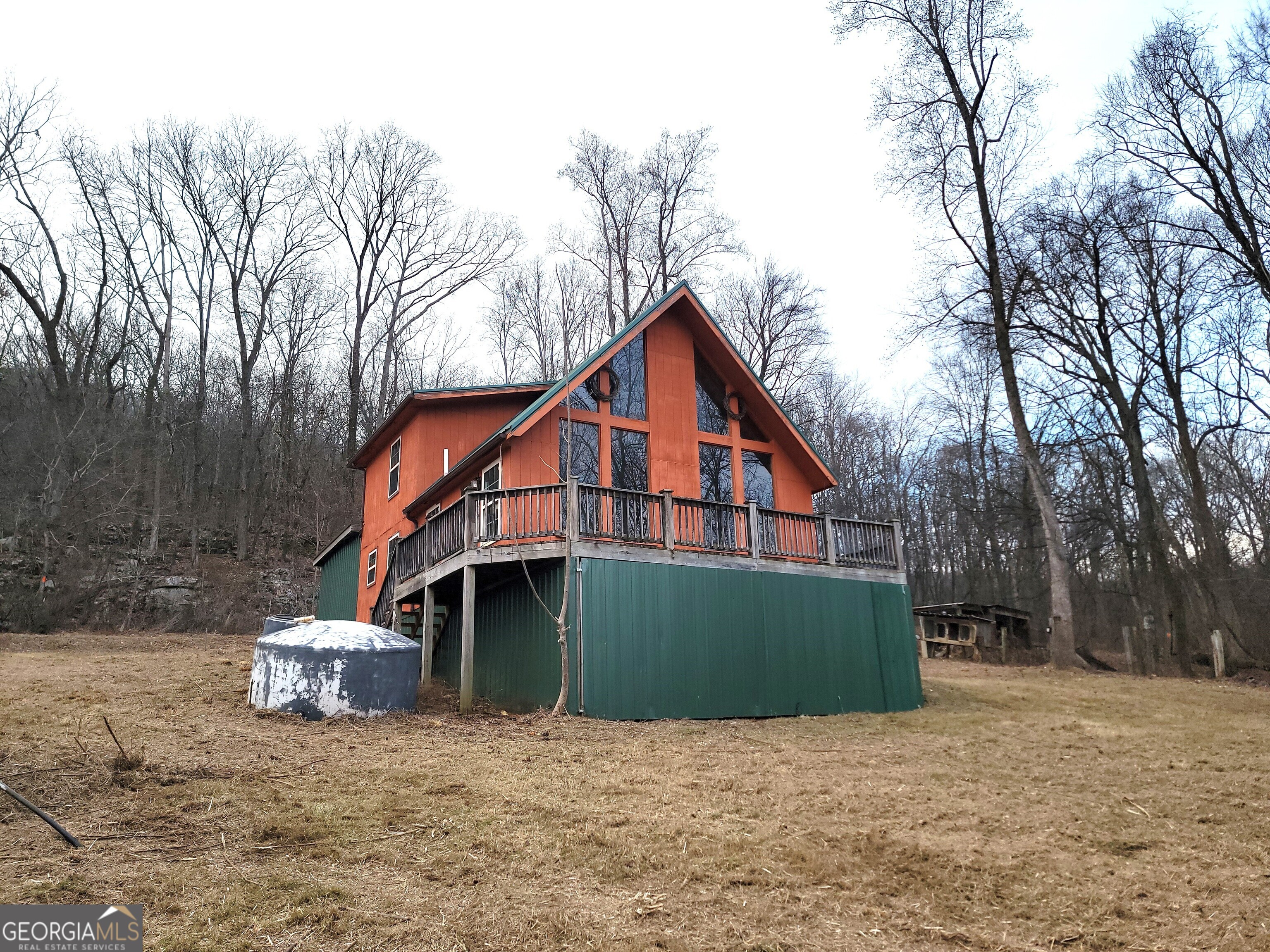 Discover the serenity of living completely off the grid with this captivating cabin nestled on 18.38 +/- acres, offering great views of the Georgia Mountains. This property is a nature lover's dream, featuring a creek and mature hardwoods that enhances its appeal. The cabin itself is awaiting your personal touch. While it requires some TLC to finish it up, the potential is limitless. Equipped with functional 4x4 solar panels on the roof, you'll enjoy sustainable energy that powers your off-grid lifestyle. The cabin boasts an on-demand propane gas water heater and a generous 4,200-gallon water tank, ensuring you have everything you need for comfortable living. Warm your space with the cozy Ashley wood-burning stove, perfect for chilly nights spent enjoying the sights and sounds of nature. For those passionate about woodworking, the property includes a Hudson 30" band saw with a 20' bed. Also included is a 2-bedroom, 2-bath mobile home that is move-in ready and easily accessible. This additional residence features reliable well water, power, and its own septic tank, making it perfect for guests, family, or as a rental opportunity. This rare find provides an incredible opportunity to embrace a simpler lifestyle while immersing yourself in the beauty of nature. Please note that the property is sold "AS IS," Don't miss the chance to own this off-grid property where peace and personal creativity meet. Schedule a viewing today and begin envisioning your future in this idyllic setting!